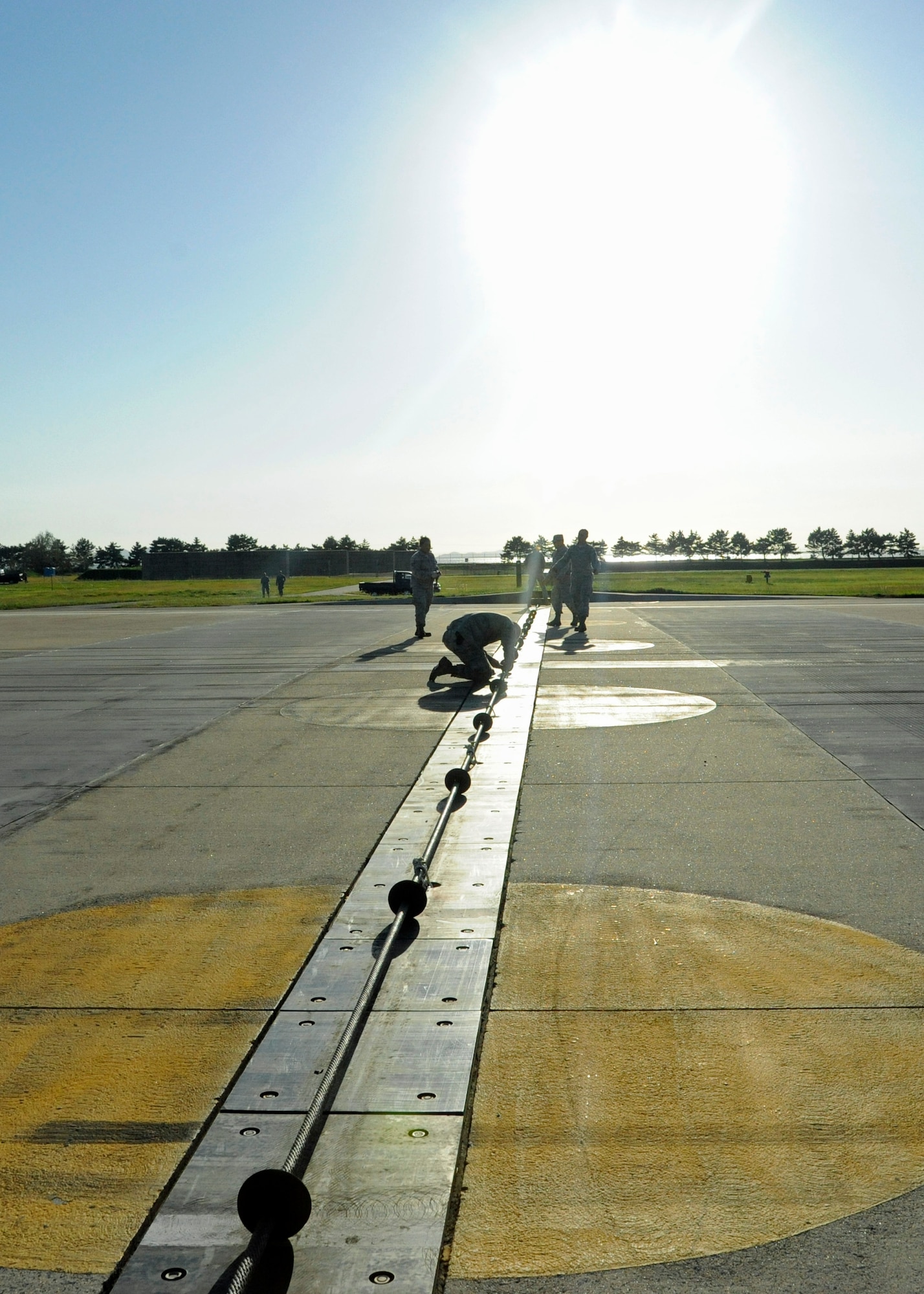 Airmen assigned to the 8th Civil Engineer Squadron prepare to certify a new Barrier Arresting Kit-12 system on the flight line at Kunsan Air Base, Republic of Korea, Sept. 17, 2013. These barriers are in place to save the pilot's life and the multi-million dollar aircraft in case of an in-flight emergency such as battle damage, loss of hydraulics, an aborted takeoff or other malfunctions. (U.S. Air Force photo by Staff Sgt. Jessica Haas/Released)