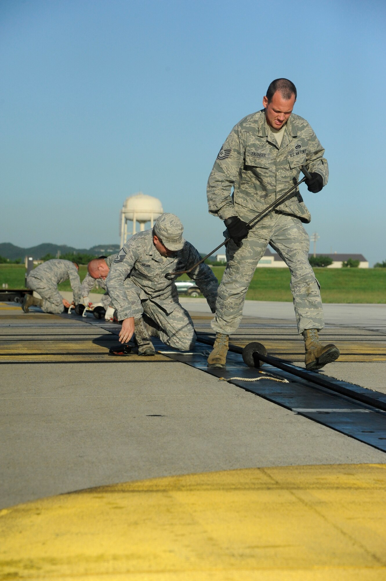 Airmen assigned to the 8th Civil Engineer Squadron prepare to certify a new Barrier Arresting Kit-12 barrier on the flight line at Kunsan Air Base, Republic of Korea, Sept. 17, 2013. These barriers are in place to save the pilot's life and the multi-million dollar aircraft in case of an in-flight emergency such as battle damage, loss of hydraulics, an aborted takeoff or other malfunctions. (U.S. Air Force photo by Staff Sgt. Jessica Haas/Released)