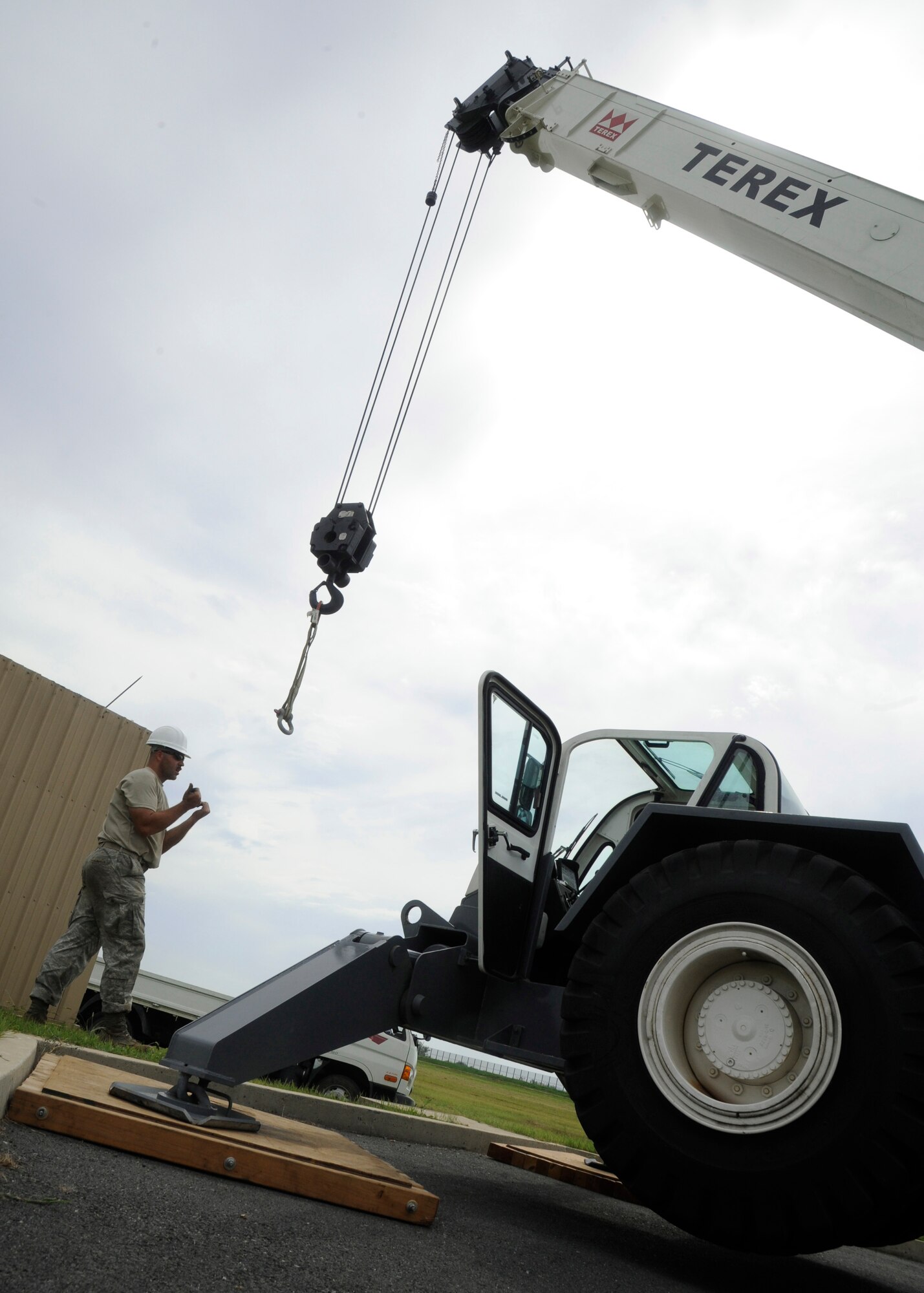 Staff Sgt. Maxwell Evans, 8th Civil Engineer Squadron, directs the crane operator while installing new Barrier Arresting Kit-12 systems on the flight line at Kunsan Air Base, Republic of Korea, Sept. 2, 2013. The 8th CES worked hard installing these Arresting systems to ensure the Wolf Pack is always ready to take the fight North. (U.S. Air Force photo by Staff Sgt. Jessica Haas/Released)