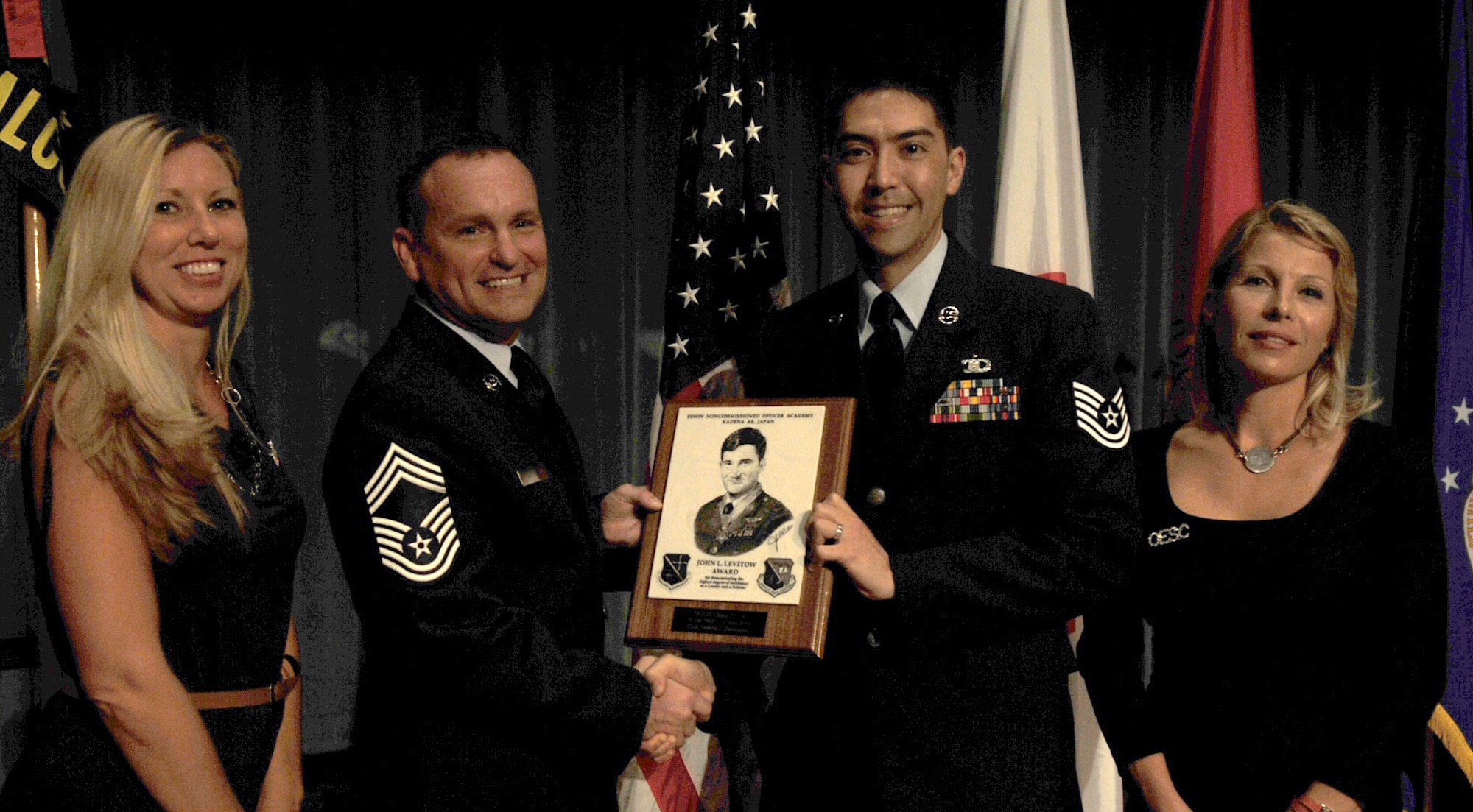 U.S. Air Force Chief Master Sgt. Michael Radford, 18th Equipment Maintenance Squadron maintenance flight chief, presents Tech. Sgt. Simon Swengler, 374th Operations Support Squadron flight chief, Yokota Air Base, Japan, the John L. Levitow award during the NCO Academy Class 13-6/Airman Leadership School Class 13-F combined graduation ceremony at the Keystone Theater on Kadena Air Base, Japan, Sept. 13, 2013. This distinguished graduate award, named in memory of Medal of Honor recipient Airman 1st Class John L. Levitow, is presented to the most outstanding member of professional military education and denotes superior achievement as both a leader and a scholar. (U.S. Air Force photo by Naoto Anazawa)