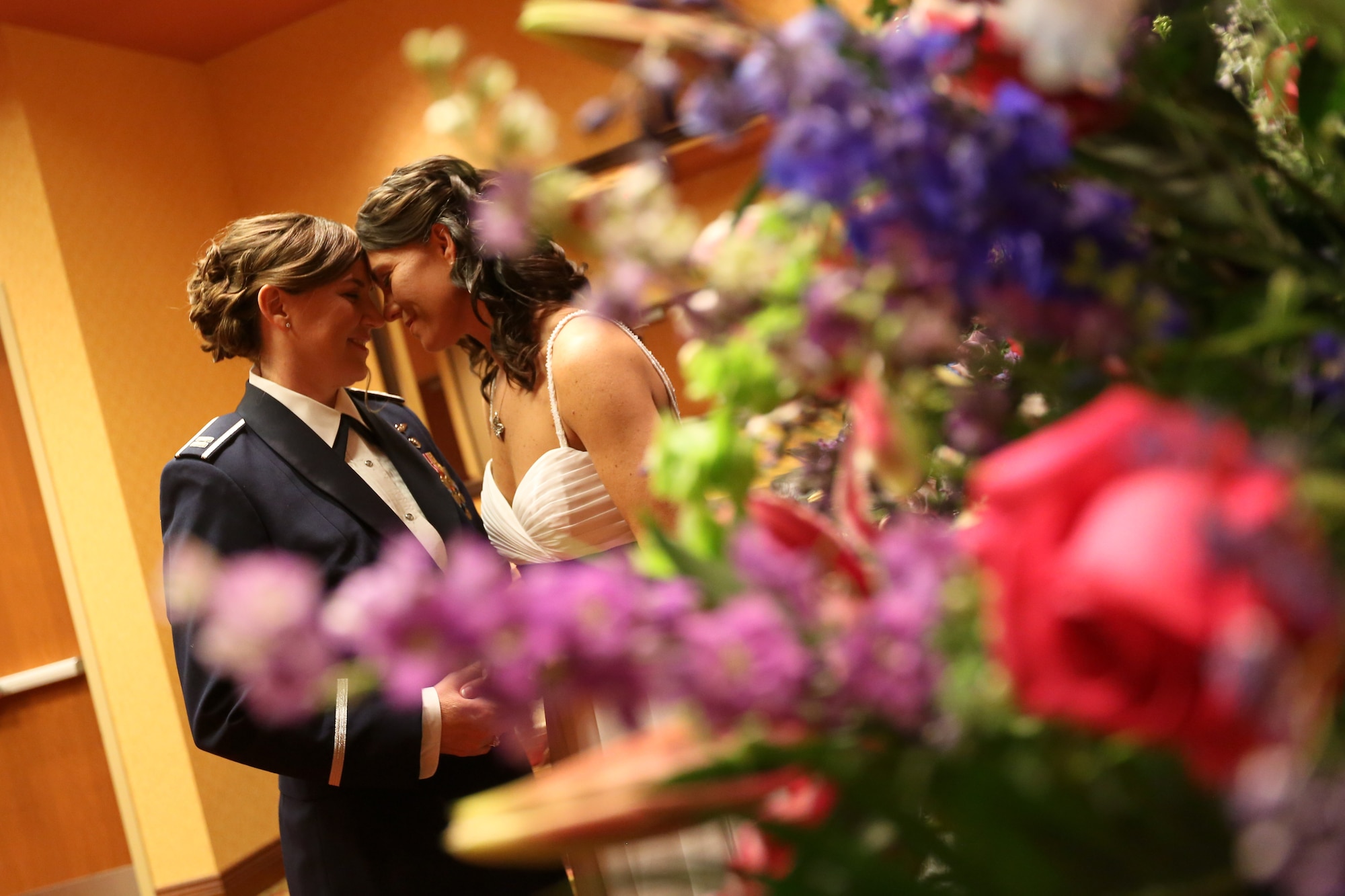 Capt. Dawn Tanner, 51st Medical Operations Squadron Family Advocacy element leader, and Dana McCown, retired lieutenant colonel, share their first glimpse of each other before their wedding ceremony in Omaha, Neb., May 3, 2013. Recent legislation has given service members and dependents in same-sex marriages access to the same benefits and assignment opportunities as heterosexual couples, but those assigned to United States Forces Korea and governed under the Status of Forces Agreement continue to wait for theater-specific entitlements. (U.S. Air Force Courtesy Photo/Capt. Dawn Tanner)