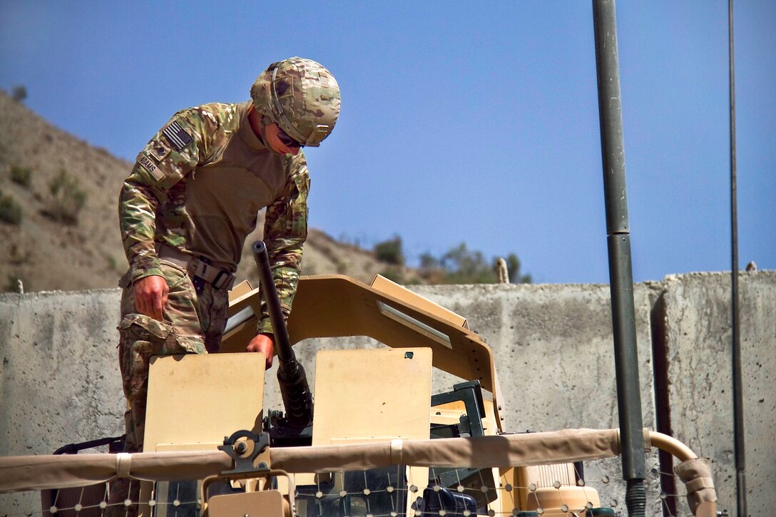 A U.S. soldier prepares his .50-caliber machine gun before moving out on a security mission for a bridge being built in Paktya province, Afghanistan, Aug. 31, 2013.