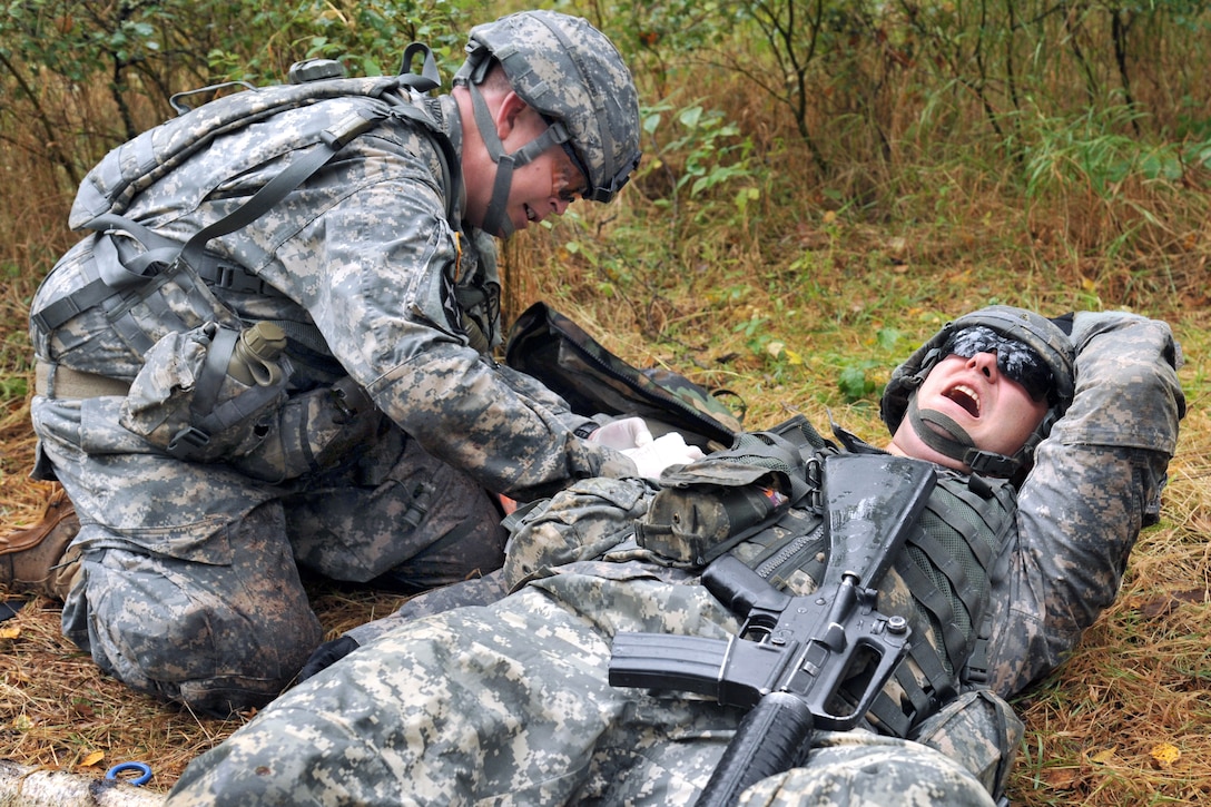 U.S. Army Sgt. 1st Class Roy Richards applies a field dressing to a simulated casualty during the U.S. Army Europe Expert Field Medical Badge Competition on Grafenwoehr Training Area, Germany, Sept. 13, 2013.