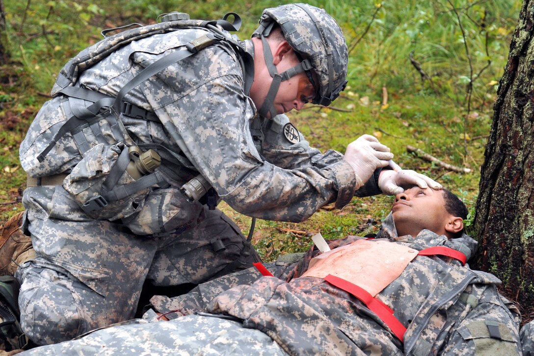 U.S. Army Sgt. 1st Class Roy Richards checks the vision of a simulated casualty during the U.S. Army Europe Expert Field Medical Badge Competition on Grafenwoehr Training Area, Germany, Sept. 13, 2013.