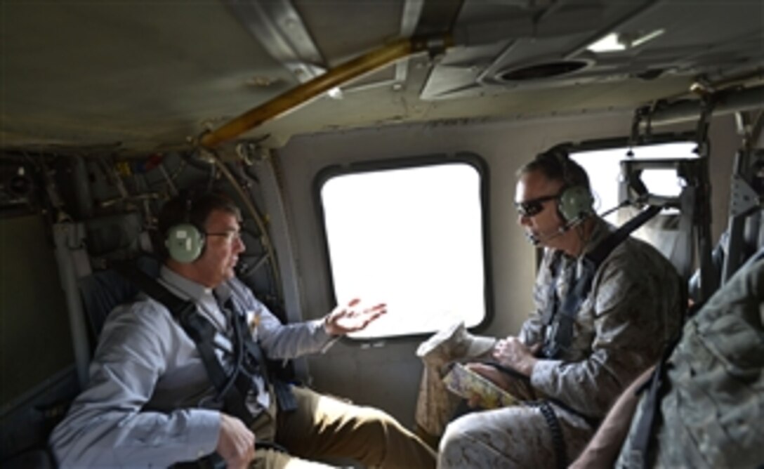 Deputy Secretary of Defense Ashton B. Carter, left, talks to Marine Corps Gen. Joseph Dunford, commander of the International Security Assistance Force, as they helicopter to a forward base in Afghanistan on Sept. 15, 2013.  Carter is on a weeklong trip to Afghanistan, Pakistan and India to meet with senior leaders and troops deployed to the region.  