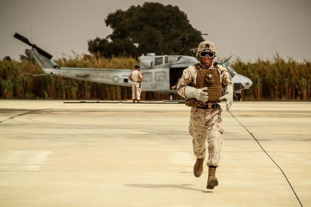 Sergeant Joshua Aubrey of Louisville, Ky., sprints off the landing zone after fast roping off a helicopter during sustainment drills.  The squad leader, along with the rest of the Marines and sailors of Africa Partnership Station 13, participated in the training as part of months of various training exercises and courses to ensure a successful rotation to Africa. 