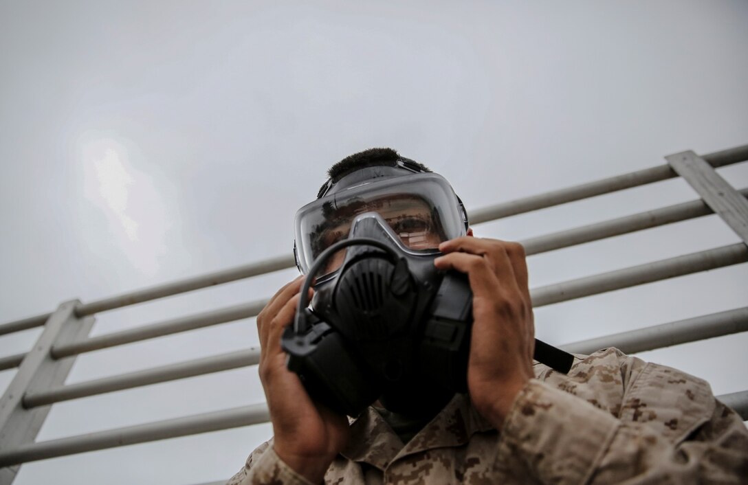 Corporal Albert Perez III, administrative specialist, 15th Marine Expeditionary Unit, tests the seal of his M50 Joint Service General Purpose Mask during his unit’s chemical, biological, radiological and nuclear defense mask confidence training at Camp Margarita aboard Camp Pendleton, Calif., Sept. 17. Perez, 21, is a native of Los Angeles. (U.S. Marine Corps photo by Cpl. Emmanuel Ramos/Released)