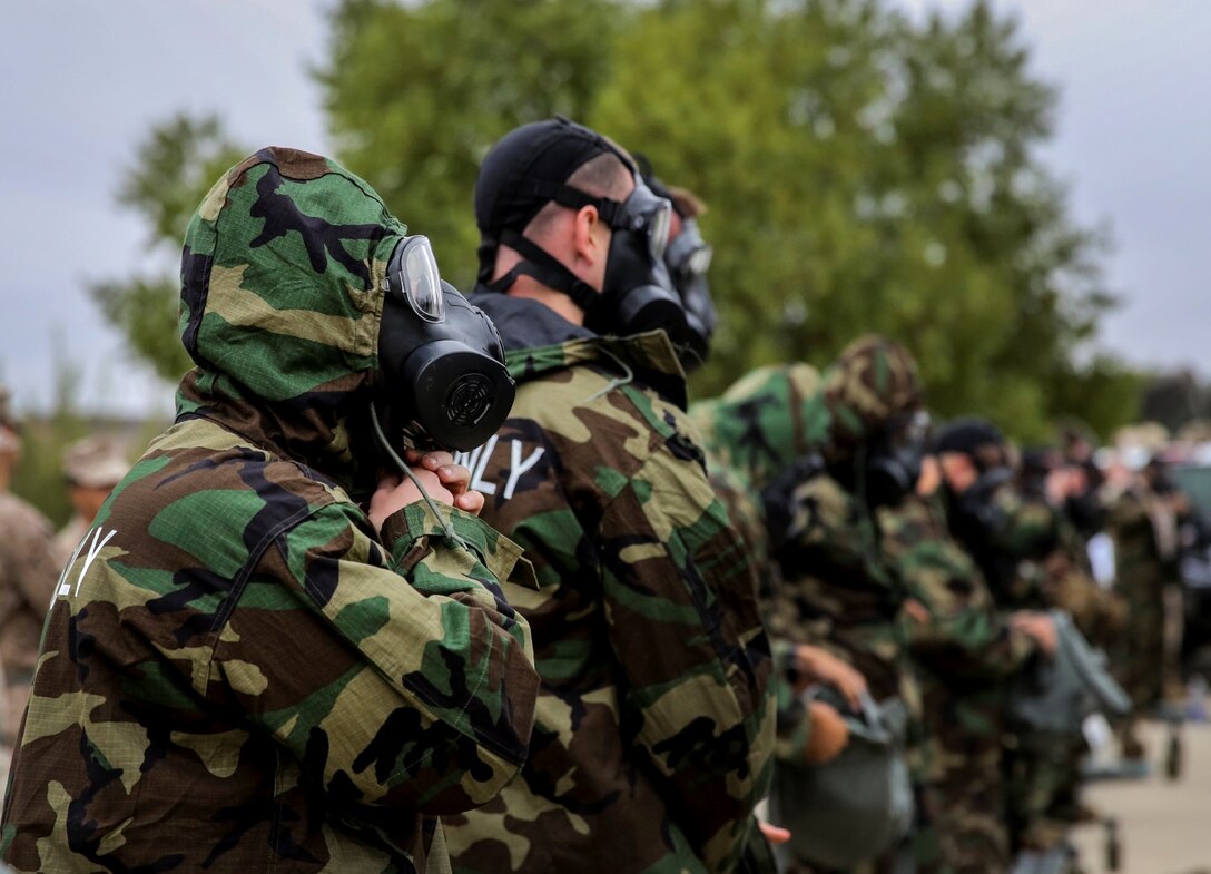 Marines with the 15th Marine Expeditionary Unit put on mission-oriented protective posture level four protective gear during their unit’s chemical, biological, radiological and nuclear defense mask confidence training at Camp Margarita aboard Camp Pendleton, Calif., Sept. 17. (U.S. Marine Corps photo by Cpl. Emmanuel Ramos/Released)