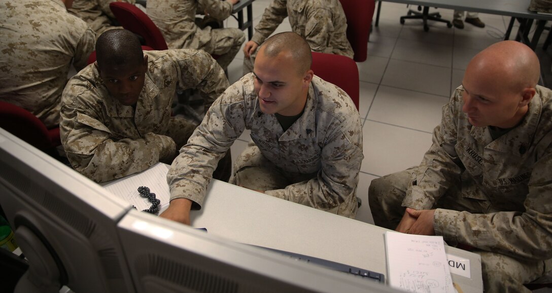 Marines with 6th Marine Regiment, 2nd Marine Division, analyze their battle position during a training command post exercise inside the II Marine Expeditionary Force Simulation Center aboard Marine Corps Base Camp Lejeune Sept. 18, 2013. Major Kemper Jones, the operations officer for 6th Marines, said the training simulated how the regiment’s command operation center communicates with subordinate commands during a real-life operation. “We are doing this to refine our skills as a regimental command and control element,” Jones said. 