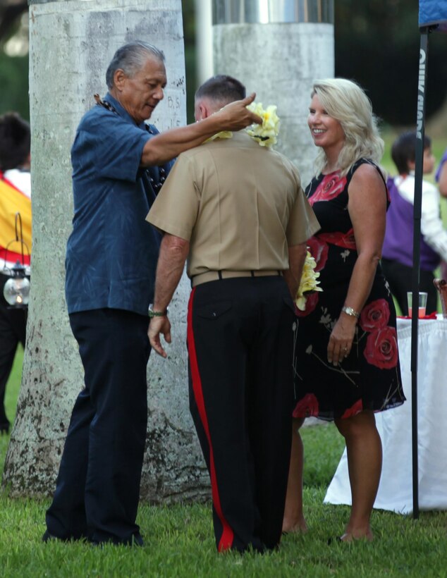 Kumu hula(hula instructor) Makua Kalani Apana, the instructor for the Iroquois Point Elementary School, places a lei on Lt. Gen. Terry G. Robling, commander of U.S. Marine Corps Forces, Pacific, Sept. 15. The students performed a traditional hula as part of the centennial ceremony for Marine Corps Officers’ Quarters here. The three Renaissance-style, single-family homes, including the “Chesty Puller House,” were completed in 1913.