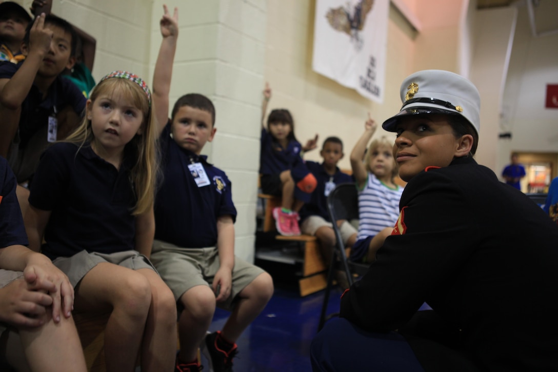 NAVAL AIR STATION JOINT RESERVE BASE NEW ORLEANS, La. – Lance Cpl. Olivia Goncalves, a Marine Forces Reserve administrative specialist and color guard member, answers questions from children with Cub Scout Pack 454 at Belle Chasse Academy here, Sept. 12, 2013. Marines from the MARFORRES color guard attended the troops’ first meeting of the school year to demonstrate and teach proper color guard skills and procedures. (U.S. Marine Corps photo by Lance Cpl. Tiffany Edwards)