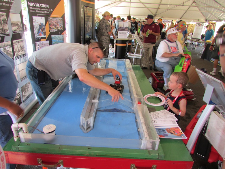 Sam Mathiowetz, an equipment repairman at Lock and Dam 1 in Minneapolis, demonstrates how a lock on the nation’s inland waterway system works to one of the young visitors to stop by our booth at the Minnesota State Fair’s Military Appreciation Day on August 27, 2013. Our lock model was a hit with all ages, whether it was the kid that wanted to play with the boat or the adult that’s taken his recreation craft through one of the full size facilities on the Mississippi River.