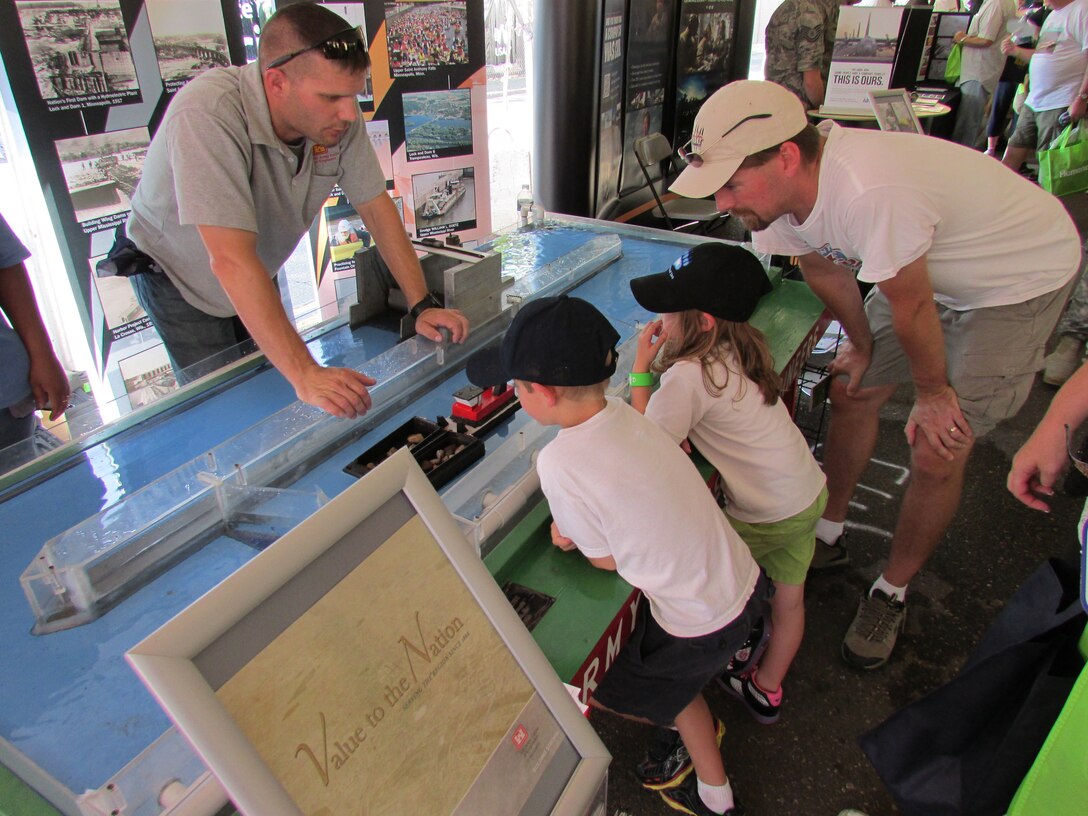 Sam Mathiowetz, an equipment repairman at Lock and Dam 1 in Minneapolis, demonstrates how a lock on the nation’s inland waterway system works to one of the young visitors to stop by our booth at the Minnesota State Fair’s Military Appreciation Day on August 27, 2013. Our lock model was a hit with all ages, whether it was the kid that wanted to play with the boat or the adult that’s taken his recreation craft through one of the full size facilities on the Mississippi River.
