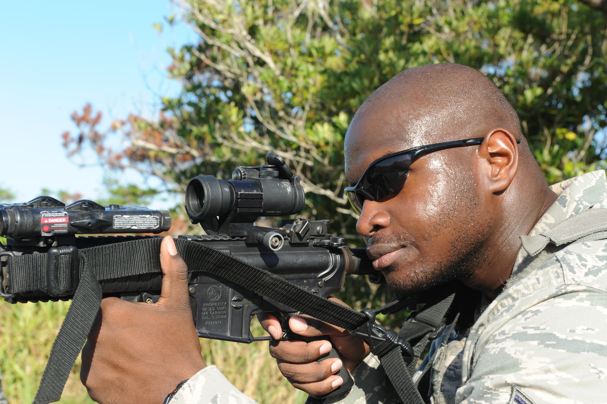 U.S. Air Force Staff Sgt. Jeffrey Henry, 18th Security Forces Squadron response force member, looks through the scope of an M-4 rifle during a training scenario on Kadena Air Base, Japan, Sept. 6, 2013. Henry, along with other 18th SFS personnel participated in a Shoot, Move, Communicate training course, which provides security forces with a realistic simulation of actually being on a battlefield and puts personnel through squad and team formations and movements while encountering an opposing force. (U.S. Air Force photo by Airman 1st Class Hailey R. Davis) 