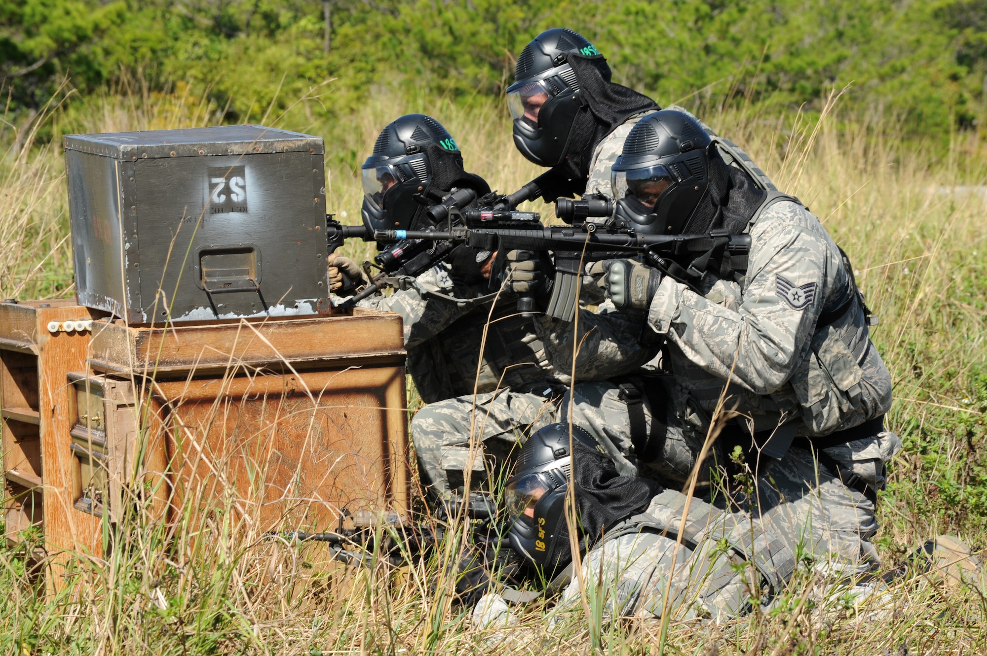 18th Security Forces Squadron personnel take cover behind a barrier during a Shoot, Move, Communicate training exercise on Kadena Air Base, Japan, Sept. 6, 2013. 18th SFS personnel participate in Shoot, Move, Communicate training courses, which provides a simulated live-fire fight for personnel, in order to maintain proficiency in communicating with teammates in combat. (U.S. Air Force photo by Airman 1st Class Hailey R. Davis)