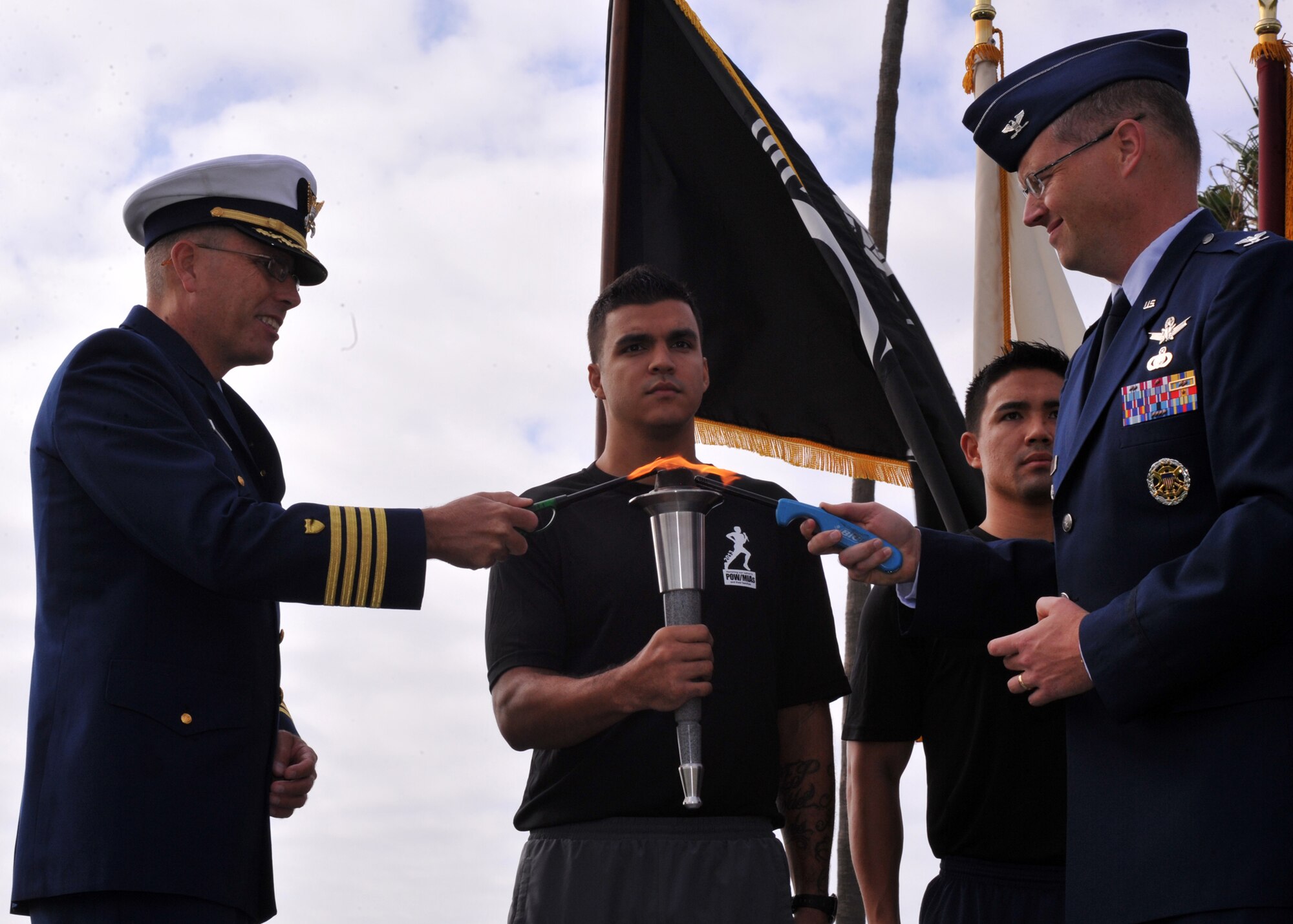 U.S. Coast Guard Capt. James Jenkins, sector commander and captain of the Port for U.S. Coast Guard Sector Los Angeles – Long Beach, far left, and U.S. Air Force Col. Steven Whitney, Senior Material leader, GPS User Equipment Division at Space and Missile Systems Center, far right, light the torch at the POW/MIA 24-Hour Relay opening ceremony, Sept. 18. The sixth annual event sponsored by the Los Angeles Air Force Base Company Grade Officers Council began at Terminal Island Coast Guard Base in San Pedro and concludes 54 miles later at Los Angeles AFB in El Segundo. (Photo by Sarah Corrice)