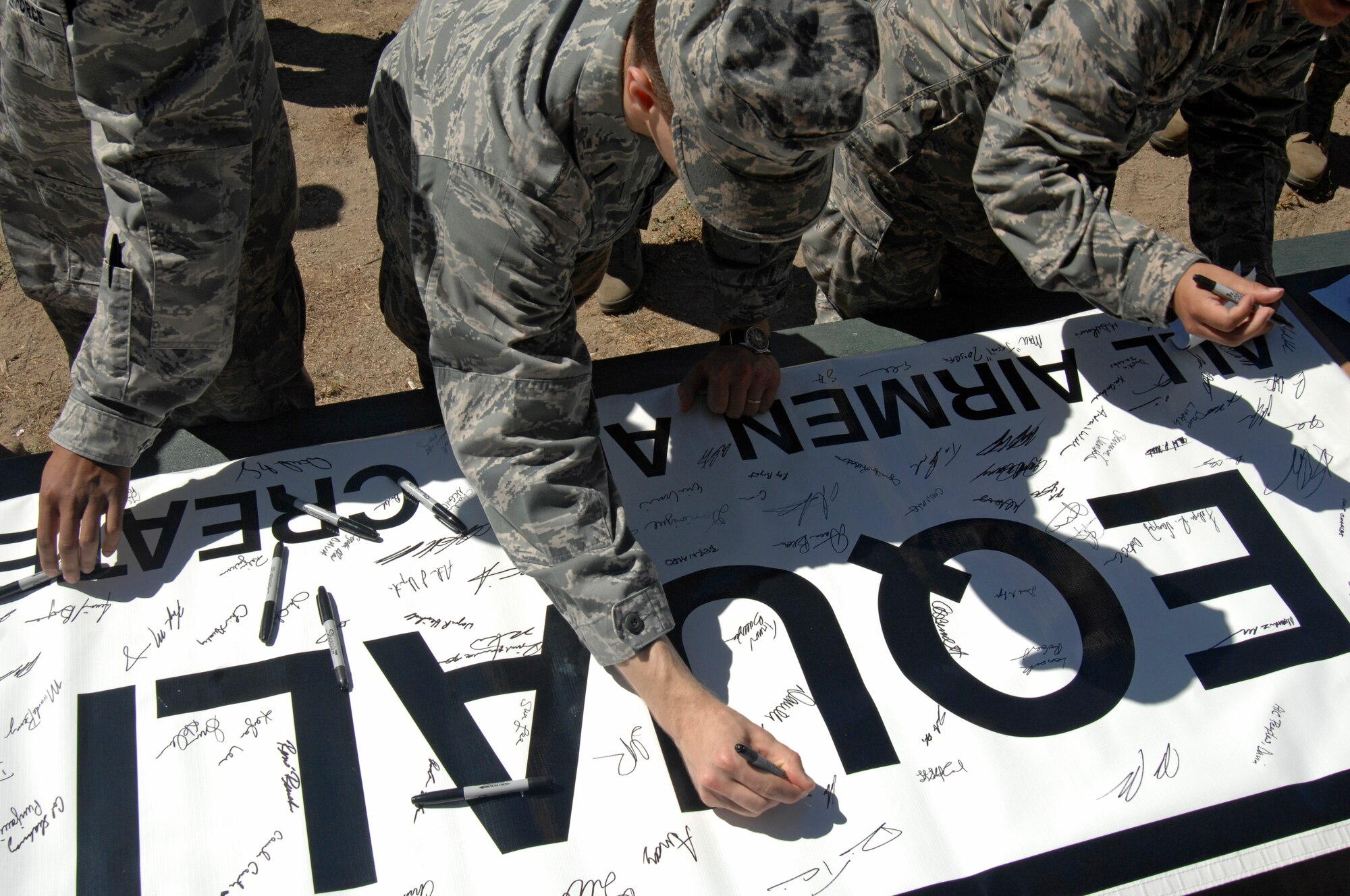 VANDENBERG AIR FORCE BASE, Calif. -- Vandenberg Airmen sign a banner representing their pledge to treat others as equals during the "Get R.E.A.L. Walk" here Tuesday, Sept. 17. During the walk, which was hosted by the 381st Training Group, Team V members were asked to change the culture and pledge their commitment to preventing sexual assaults by signing banners representing Respect, Equality, Accountability and Leadership. (U.S. Air Force photo/Michael Peterson)

