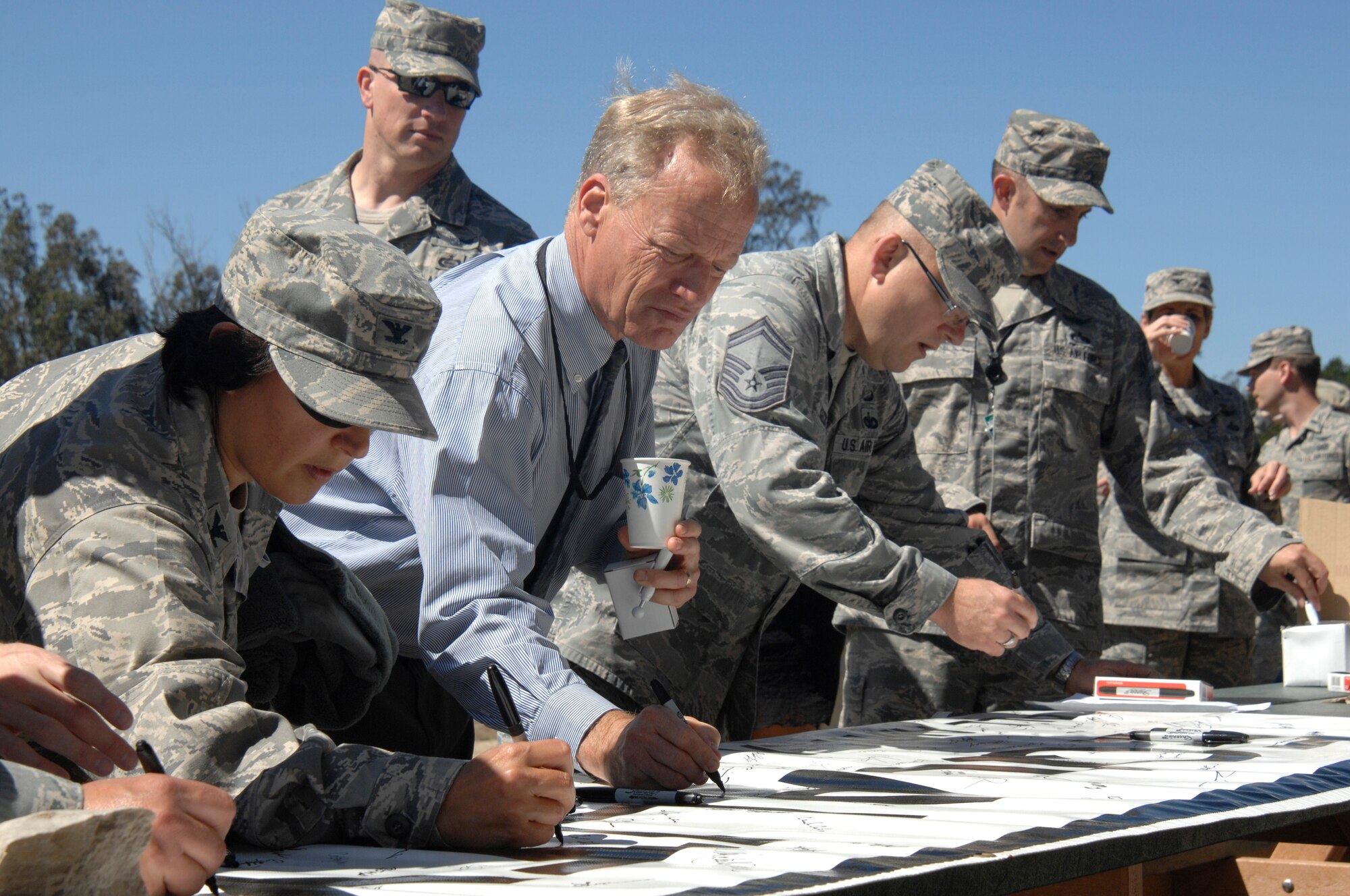 VANDENBERG AIR FORCE BASE, Calif. -- Members of a 30th Launch Group team sign a banner signifying their commitment to treat others as equals during the "Get R.E.A.L. Walk" here Tuesday, Sept. 17. During the walk, which was hosted by the 381st Training Group, Team V members were asked to change the culture and pledge their commitment to preventing sexual assaults by signing banners representing Respect, Equality, Accountability and Leadership. (U.S. Air Force photo/Michael Peterson)