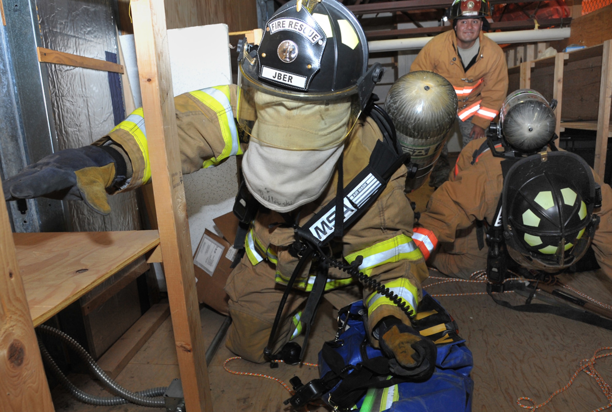 Airmen 1st Class Daniel Pudlowski and David Cullen, 673d Civil Engineer Squadron firefighters, simulate a search-and-rescue operation at Fire Station 4 on Joint Base Elmendorf-Richardson Sept. 11 as Tech. Sgt. Robert Kelly, also a 673d CES firefighter, supervises. JBER firefighters conduct daily readiness training and are expected to be able to respond to emergencies at a moment’s notice. (U.S. Air Force photo/Staff Sgt. Blake Mize)