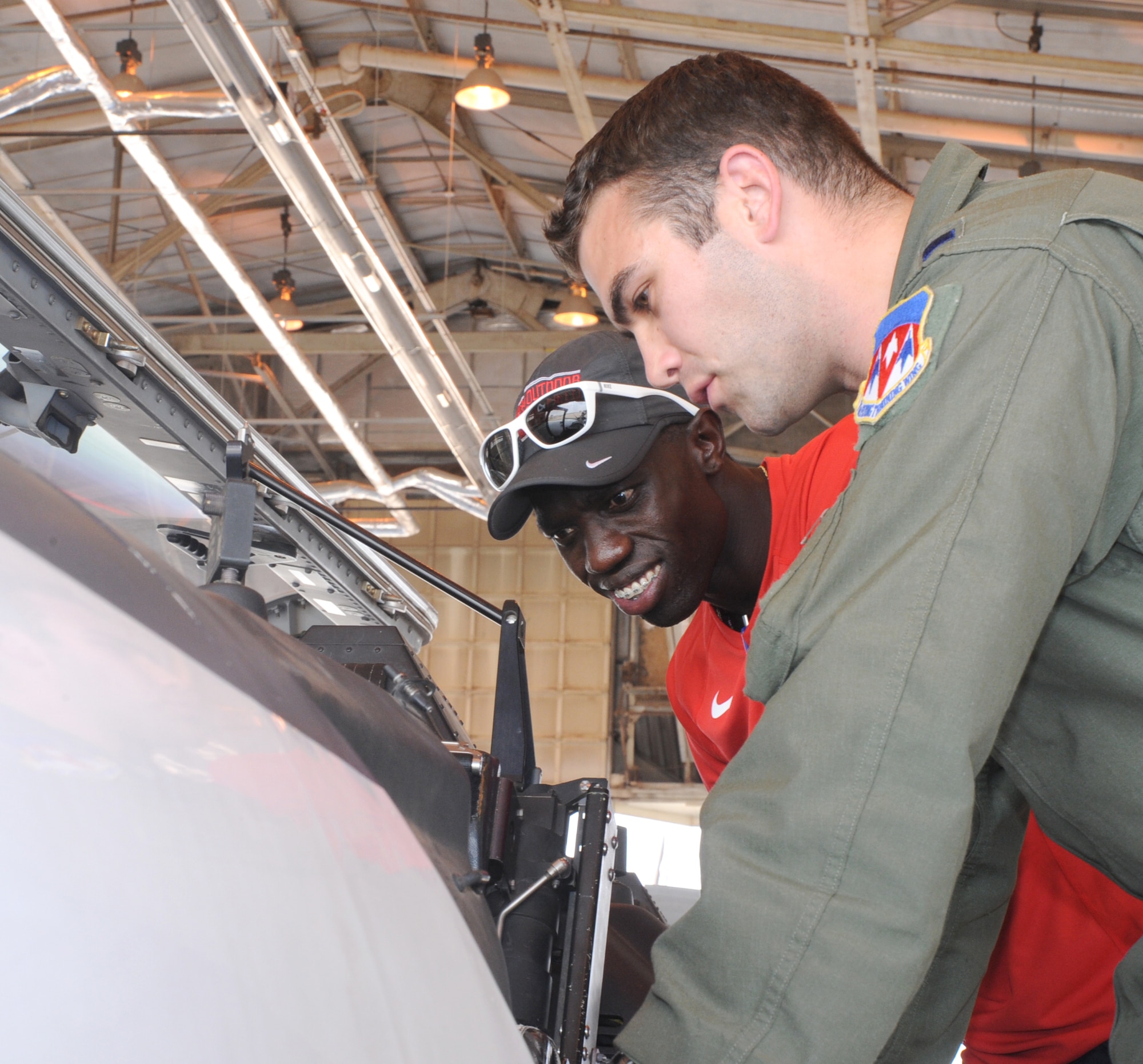 1st Lt. Jonathan Taylor, an instructor pilot with the 33rd Flying Training Squadron, front, explains the ins and outs of a T-6A Texan II to Lopez Lomond, an Olympian and public speaker, at Vance Air Force Base, Okla. Lomond came to the local area to speak at the Northern Oklahoma College about the importance of resiliency. (U.S. Air Force photo/ Senior Airman Frank Casciotta)