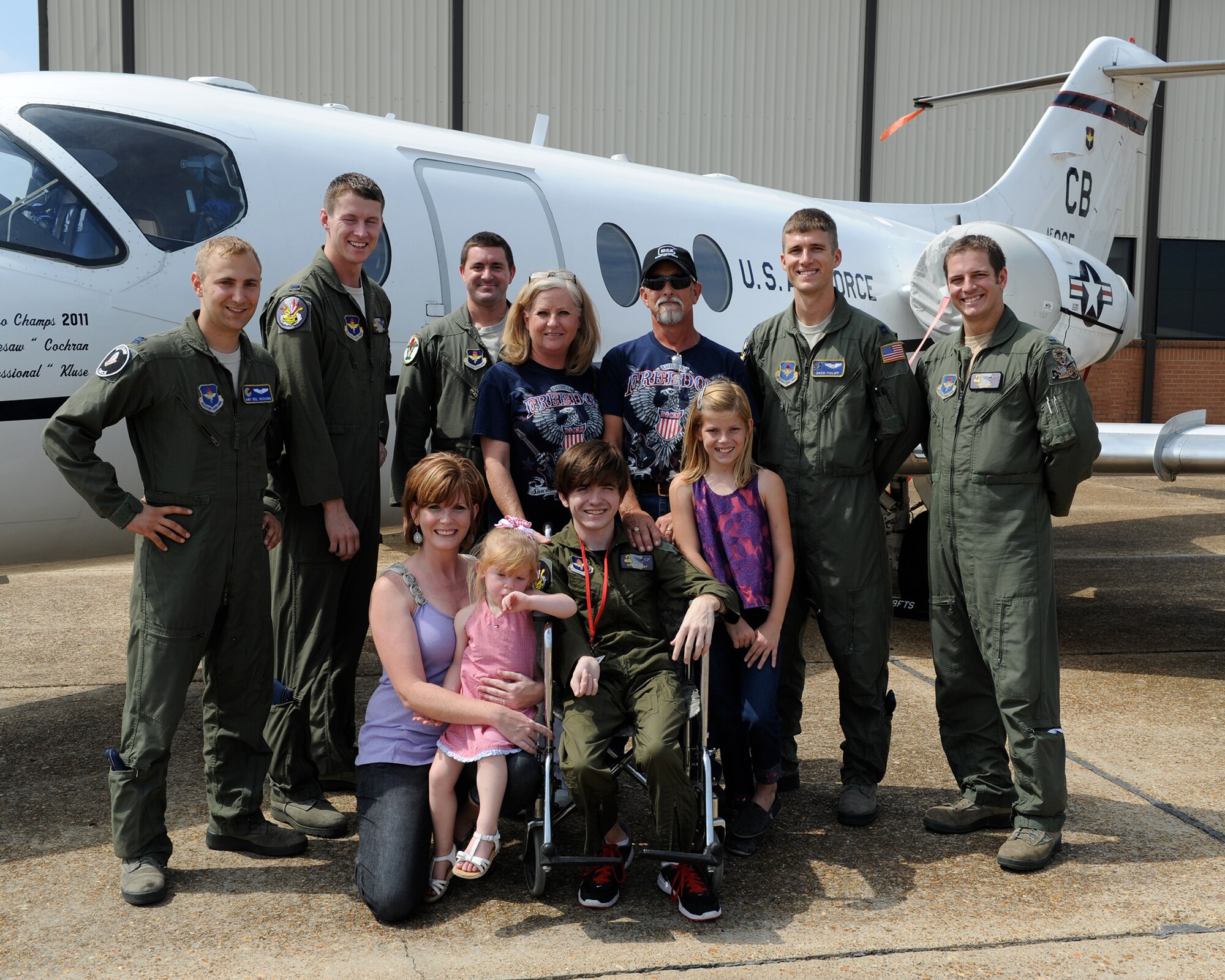 Drake West and his family pose for a photo with the pilots of the Pilot for a Day program in front of a T-1A Jayhawk on Sept. 13 on Columbus Air Force Base, Miss. West, who was part of the Pilot for a Day program, spent the day touring various facilities, learning about the planes on Columbus AFB, and even got his own patch to take home. (U.S. Air Force Photo/Elizabeth Owens)