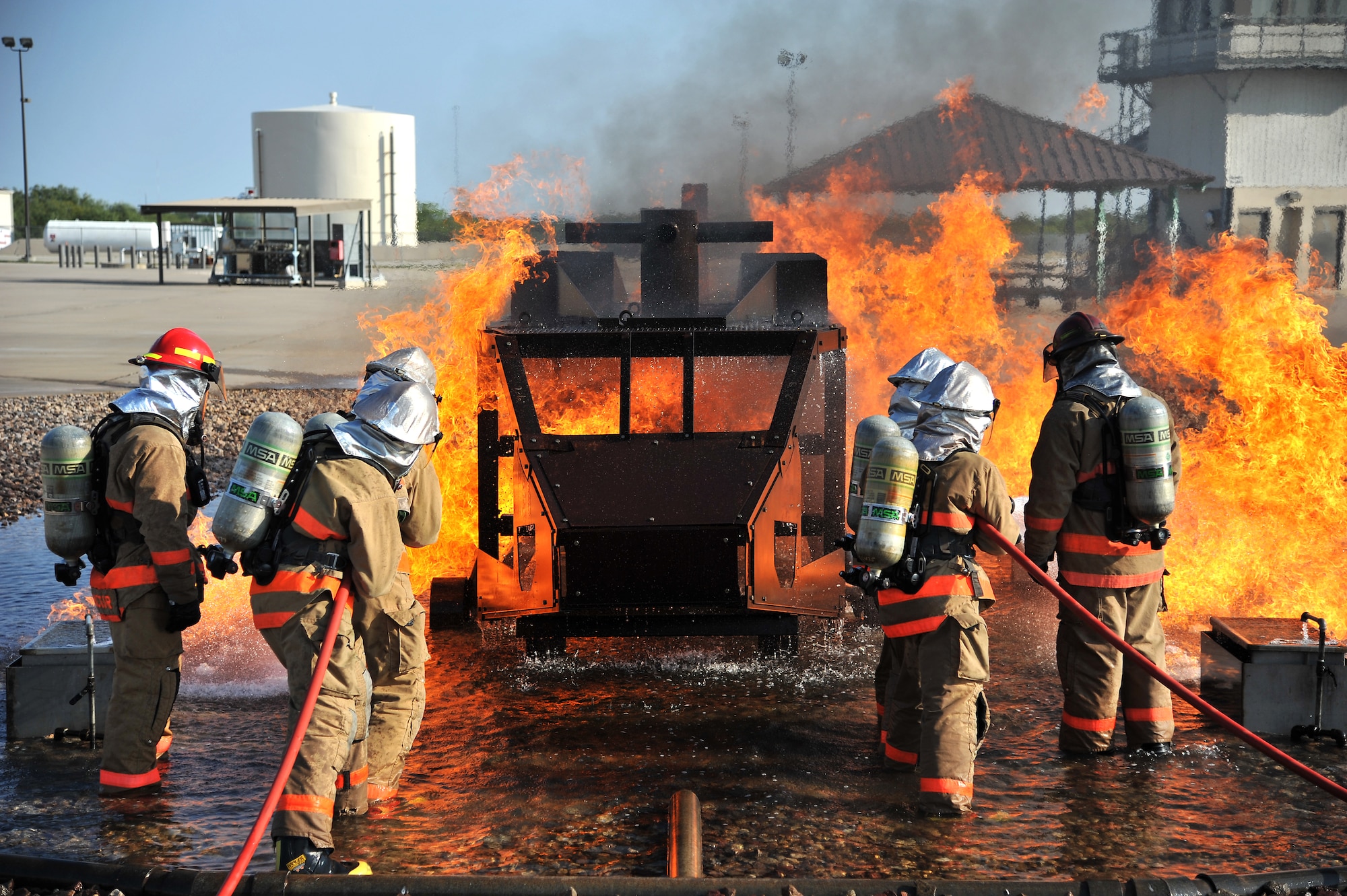 GOODFELLOW AIR FORCE BASE, Texas - Students from the 312th Training Squadron put out a fire in the Helo Trainer at the Louis F. Garland Department of Defense Fire Academy Sept. 6. Instructors watch the students extinguish the fire and help give guidance to insure proper techniques are performed. (U.S. Air Force/ Senior Airman Michael Smith)