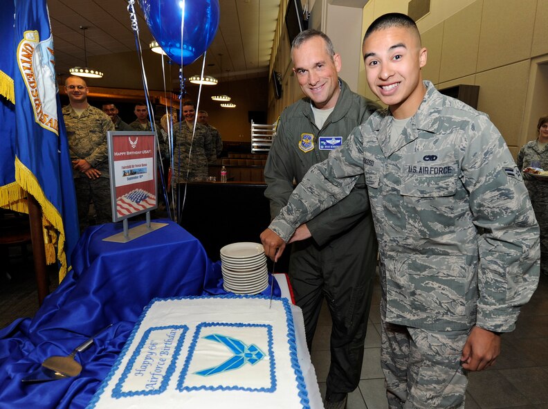 Col. Brian Newberry, 92nd Air Refueling Wing commander, cuts the Air Force birthday cake with Airman 1st Class Eduardo Fragoso, 92nd Aircraft Maintenance Squadron aerospace maintenance apprentice to celebrate the 66th Air Force birthday in the Warrior Dining Facility at Fairchild Air Force Base, Wash., Sept. 18, 2013. It is tradition that the highest ranking cuts the cake with the youngest Airman. (U.S. Air Force photo by Airman 1st Class Ryan Zeski/Released)