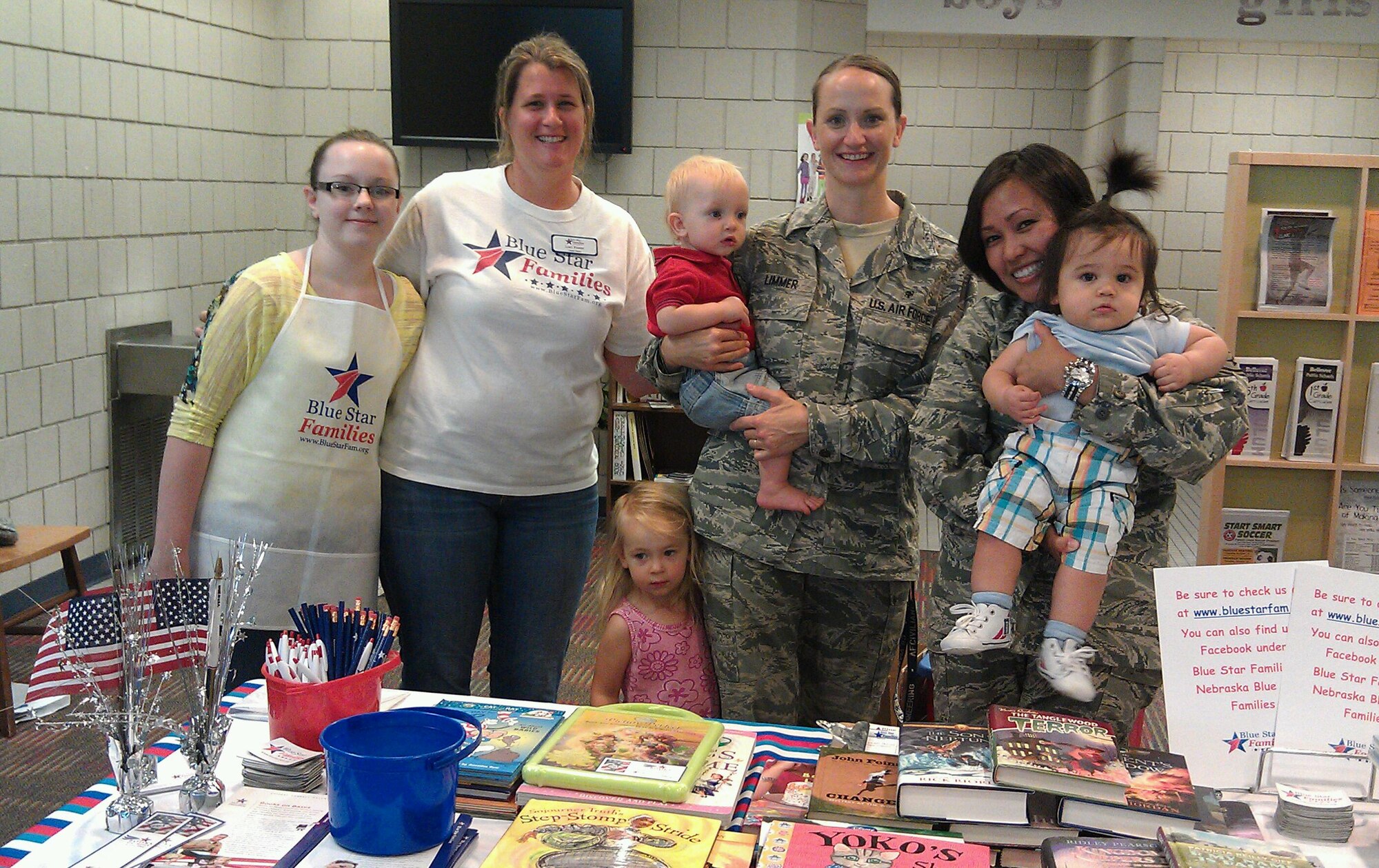 (left to right) Luci Foster, Blue Star Families Nebraska Chapter director, U.S. Air Force Master Sgt. Amanda Limmer, and U.S. Air Force Tech. Sgt. Reyna L'Italien, both of the 343rd Reconnaissance Squadron, pass out free books along with the help of their children during a special Blue Star Families Books on Bases event at the Youth Center Sept. 12 at Offutt Air Force Base, Neb. Blue Star Families is an organization whose goal is to support, connect and empower military families. During this event they provided more than 100 free books to military children. To find out more information about them, visit their website at www.bluestarfam.org. (Courtesy photo)