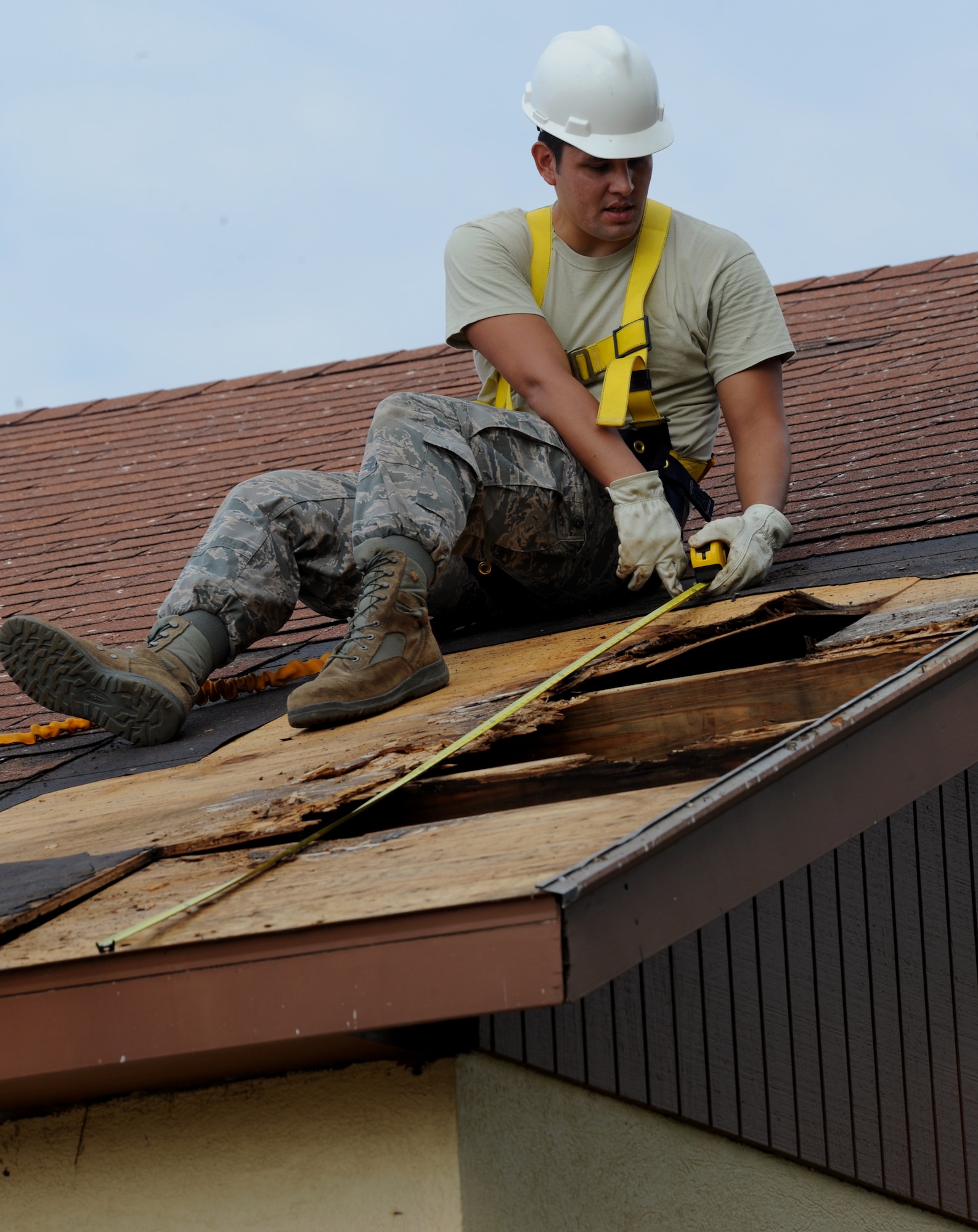 Senior Airman Pashala Lewis, 2nd Civil Engineer Squadron structures section, measures part of a roof on Barksdale Air Force Base, La., Sept. 18, 2013. In order to properly repair the roof, Lewis needs to make an accurate measurement of the material he will need. (U.S. Air Force photo/Senior Airman Benjamin Gonsier)