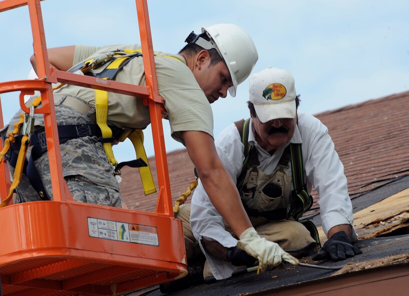Senior Airman Pashala Lewis, left, and Sweet Charlie, right, 2nd Civil Engineer Squadron structures section, remove a piece of roof decking from a building on Barksdale Air Force Base, La., Sept. 18, 2013. The 2nd CES has the responsibility of maintaining base infrastructure and setting up construction projects. (U.S. Air Force photo/Senior Airman Benjamin Gonsier)