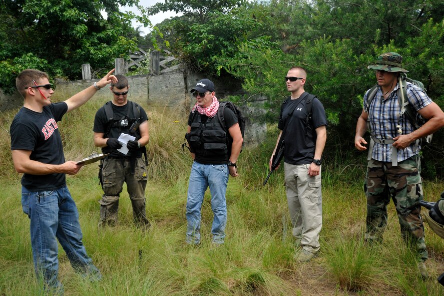 Staff Sgt. Matthew Fistler, far left, 89th Operations Support Squadron SERE specialist, directs SERE Refresher Course augmentees to rally points during an evasion exercise at Davidsonville Communications Site, Md., Aug. 21, 2013. The exercise was designed to teach survival techniques to 89th Airlift Wing aircrew in the event of an aircraft mishap and to re-qualify them on their previous SERE training. (U.S. Air Force photo/Senior Airman Lindsey A. Porter)