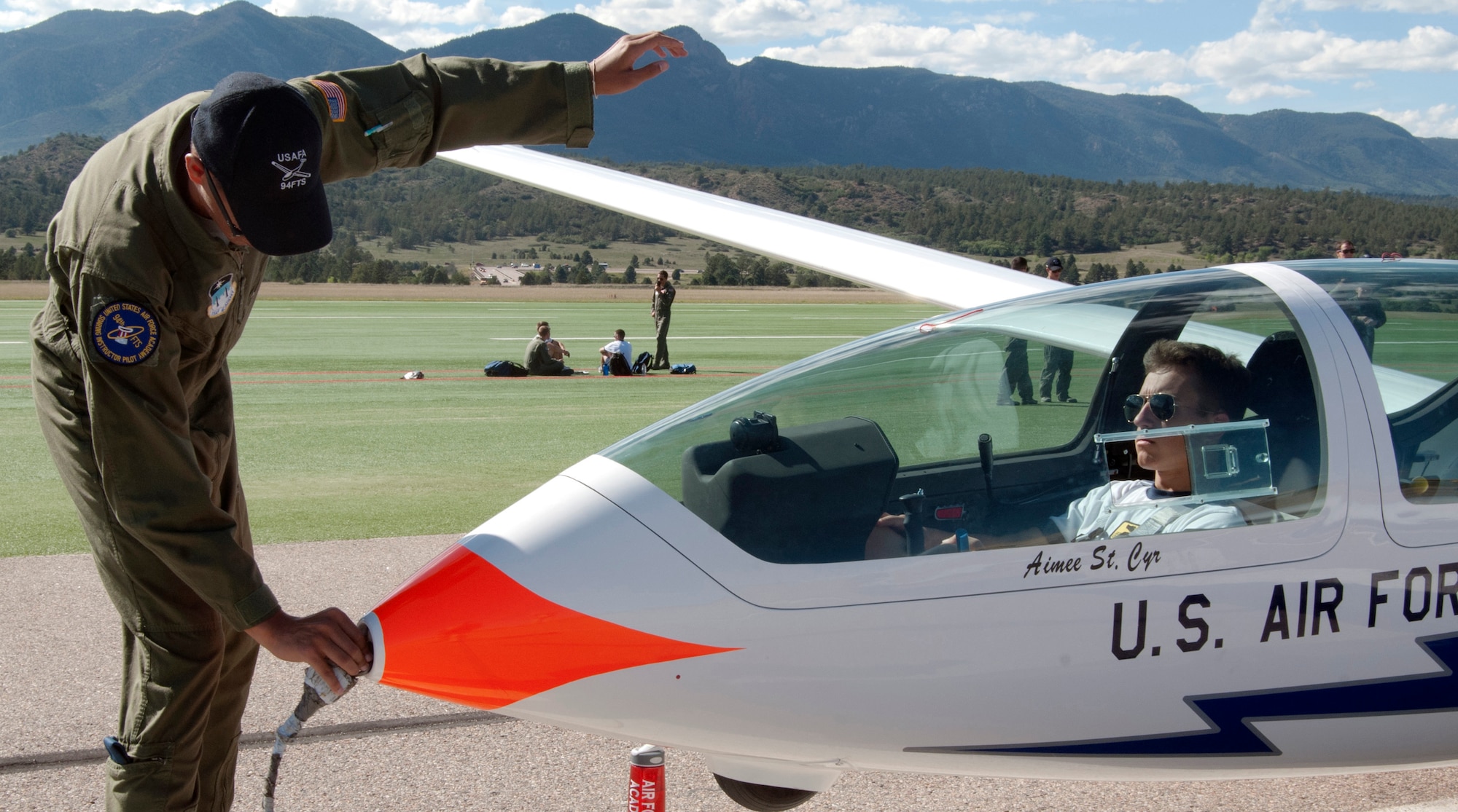 Cadet 2nd Class Joshua Wilson hooks a tow cable onto a TG-16A glider flown by Cadet 3rd Class Adam Marcinkowski at the Air Force Academy Airfield Sept. 17, 2013. The flight was the first solo for Marcinkowski, who is assigned to Cadet Squadron 30. (U.S. Air Force photo/Don Branum)