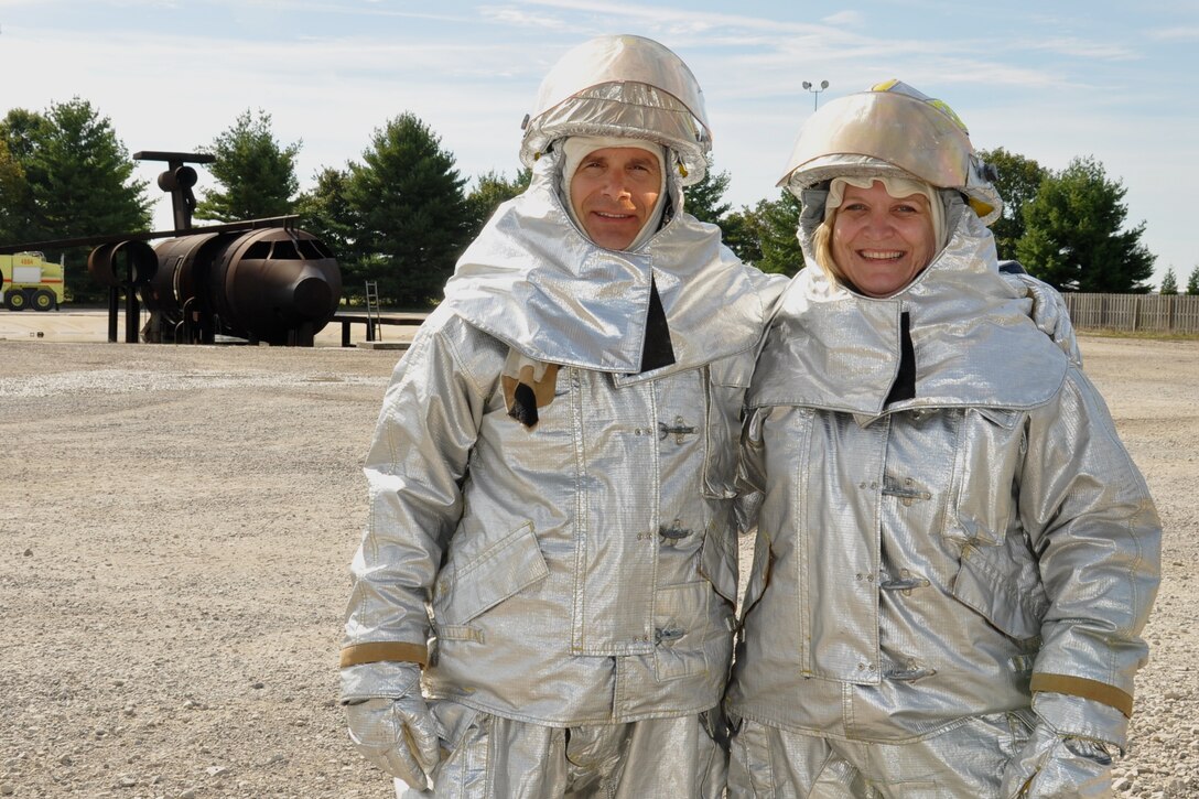Commander of the 932nd Airlift Wing, Colonel Albert Lupenski, and 932nd Mission Support Group commander, Colonel Constance Jenkins, don the fire fighting uniform to participate in a controlled burn of a mock aircraft (in the background) during annual training for the 932nd Civil Engineers Squadron.   (U.S. Air Force photo/SSgt. Amber Hodges).