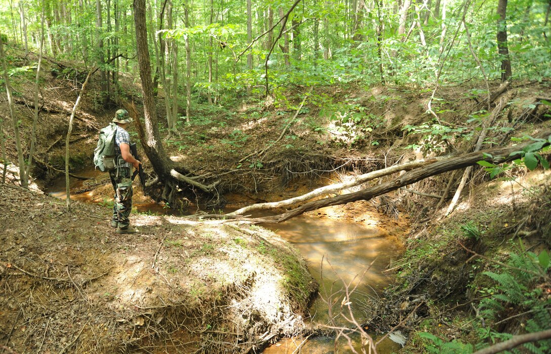 Staff Sgt. Jesse McCarley, searches for pilots from Joint Base Andrews during a training exercise at Davidsonville Communications Site, Md., Aug. 21, 2013. The exercise was designed to teach survival techniques in the event of an aircraft mishap. McCarley is the aircrew continuation training noncommissioned officer in charge with the 113th Operations Support Flight. (U.S. Air Force photo/Airman 1st Class Erin O’Shea)