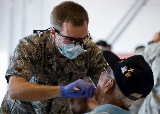 Capt. (Dr.) Austin Ladner, 99th Dental Squadron dentist, conducts an oral cancer screening during Retiree Appreciation Day at the Thunderbirds’ Hangar Sept. 13, 2013, at Nellis Air Force Base, Nev. Signs and symptoms of oral cancer include a skin lesion, lump or ulcer that does not get better in 14 days.  Additional symptoms that may be associated with oral cancer are tongue problems and swallowing difficulty. (U.S. Air Force photo by Airman 1st Class Jason Couillard)