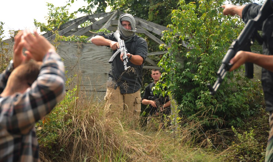 Airmen from Joint Base Andrews are held at gunpoint during a training exercise at Davidsonville Communications Site, Md., Aug. 21, 2013. The exercise was designed to teach survival techniques in the event of an aircraft mishap. (U.S. Air Force photo/Airman 1st Class Erin O’Shea)