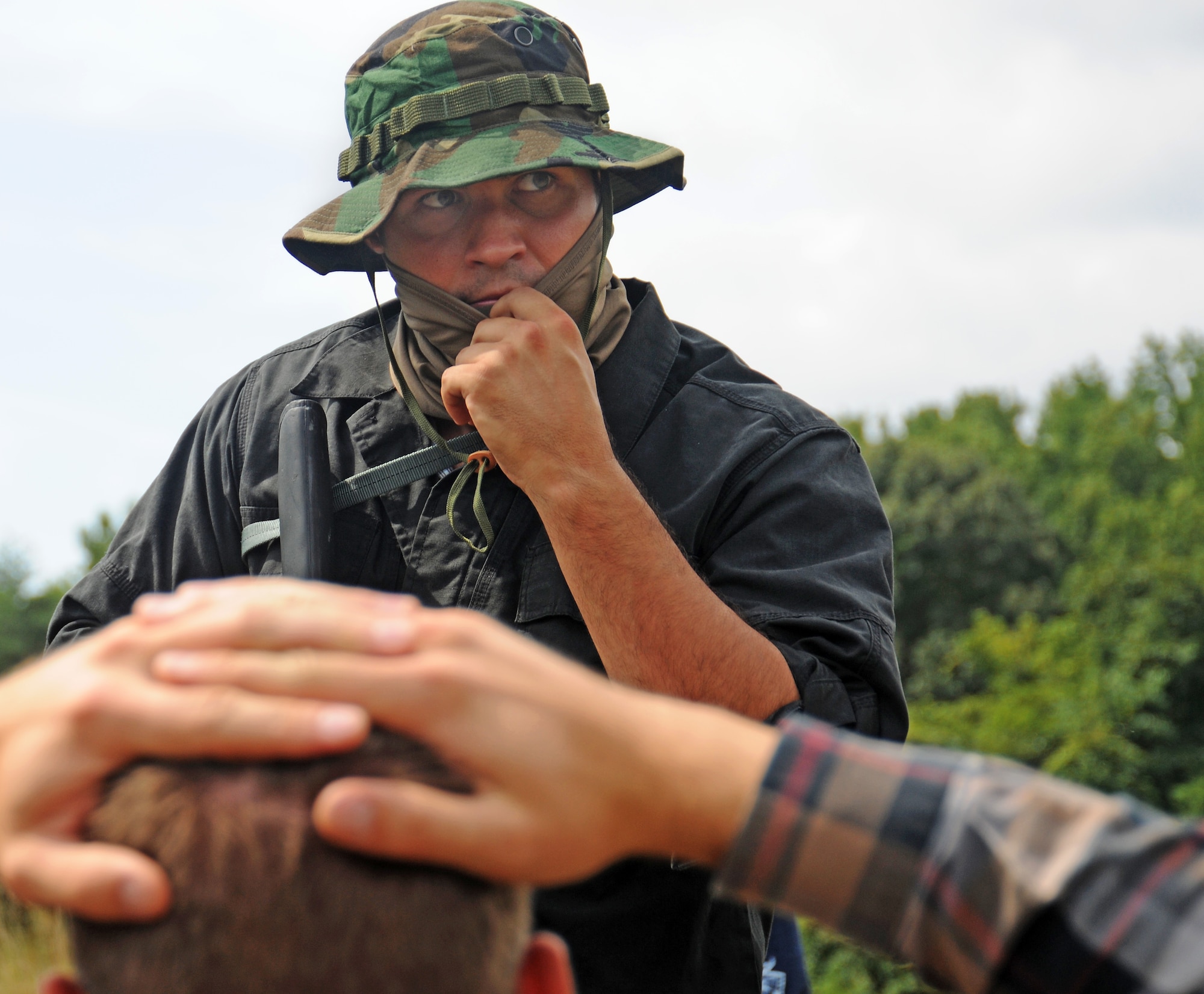 Staff Sgt. Jesse McCarley holds Staff Sgt. Matthew Fistler hostage after a vehicle hijacking exercise at Davidsonville Communications Site, Md., Aug. 21, 2013. The daylong exercise was designed to teach survival techniques in the event of an aircraft mishap or aircrew capture. McCarley is the aircrew continuation training noncommissioned officer in charge with the 113th Operations Support Flight. Fistler is a survival, evasion, resistance and escape specialist assigned to the 89th Operations Support Squadron. (U.S. Air Force photo/Airman 1st Class Erin O’Shea) 