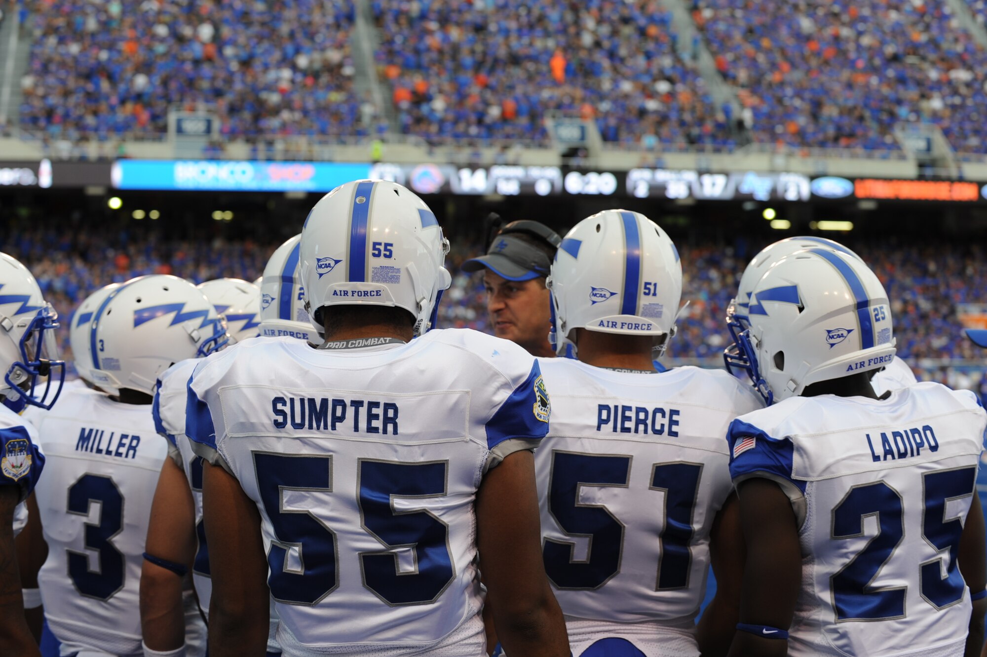 Football players from the Air Force Academy huddle up with a coach before going onto the field Sept. 13, 2013, at Bronco Stadium in Boise, Idaho. This was the second conference game for the AFA Falcons who lost their last game 52-20 against Utah State. (U.S. Air Force photo by Senior Airman Benjamin Sutton/Released) 