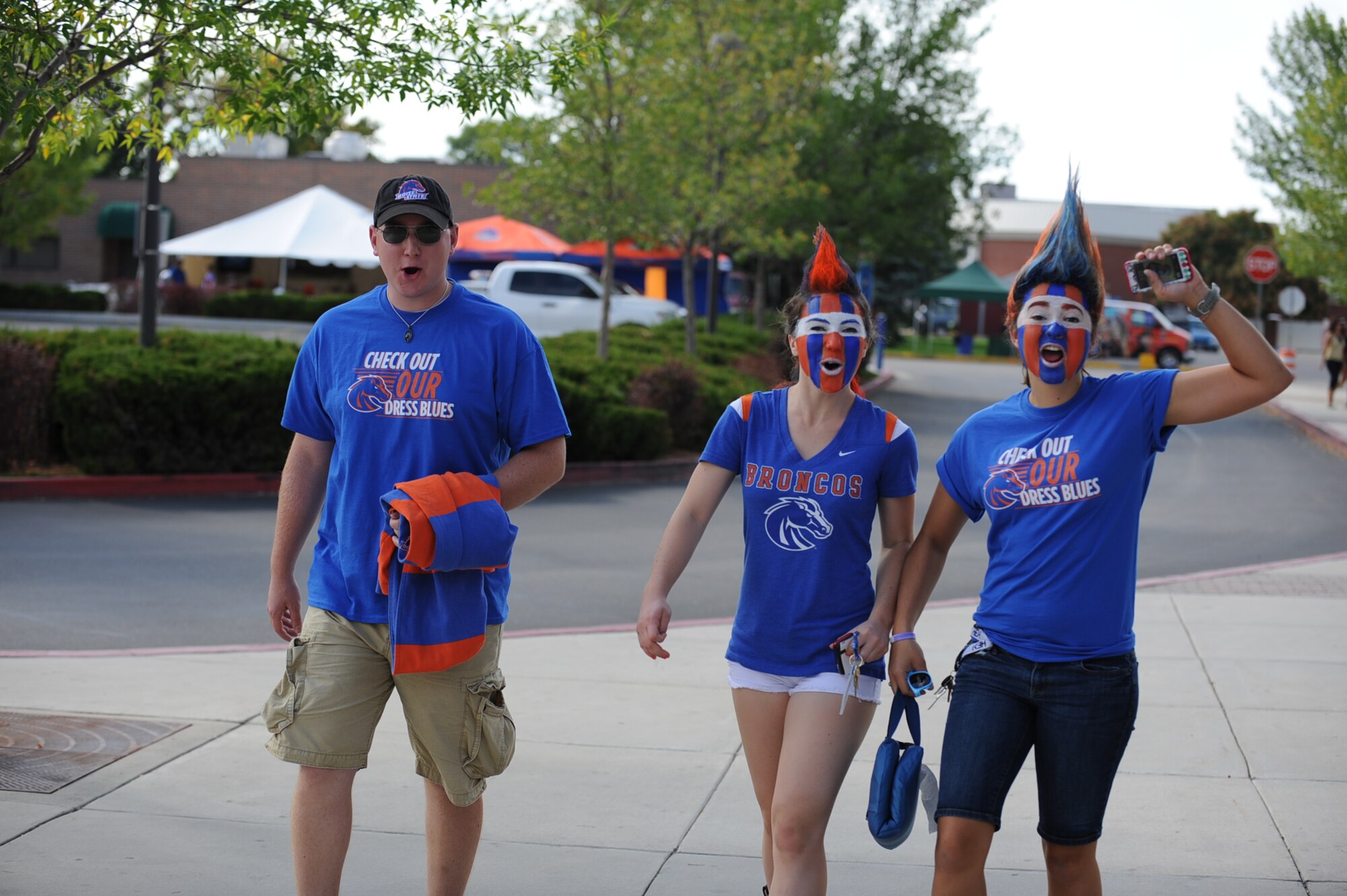 Three Boise State Broncos fans cheer before the game Sept. 13, 2013, outside Bronco Stadium in Boise, Idaho. Fans from across the city came put to support the hometown team in their Mountain West matchup against the Falcons from the Air Force Academy. (U.S. Air Force photo by Senior Airman Benjamin Sutton/Released) 