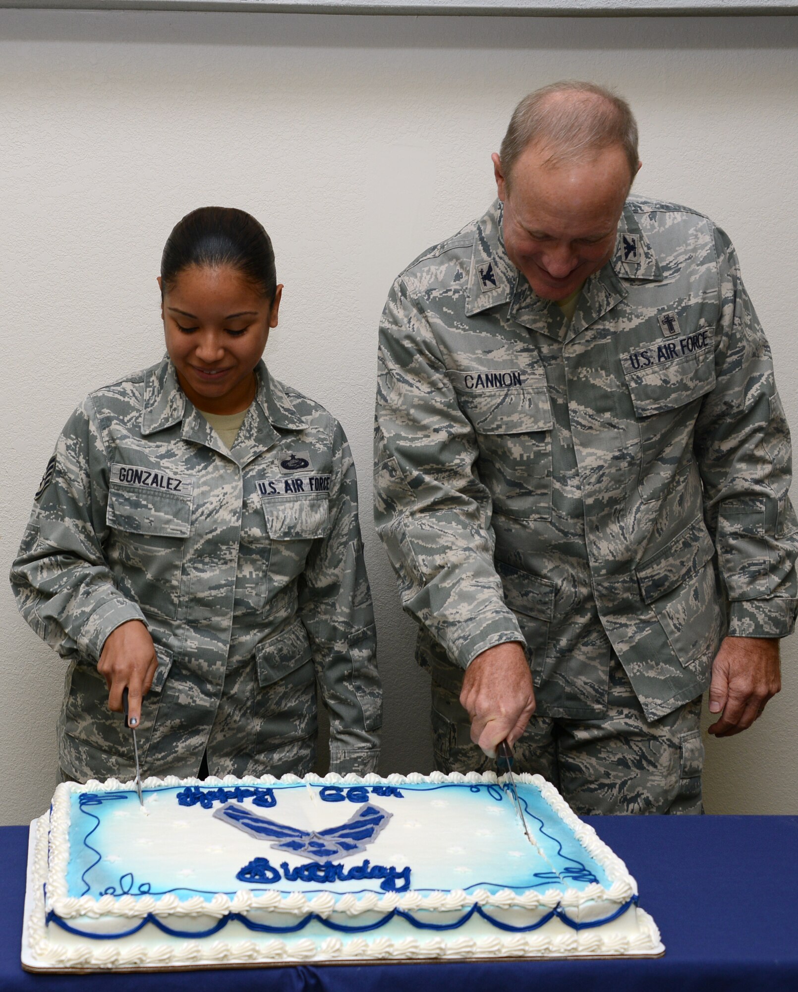 Staff Sgt. Irene Gonzales, Air Force Special Operations Command Commander's  Support Staff NCO in charge of evaluations, and Chaplain (Col.) Paul Cannon, AFSOC command chaplain, cut the cake during the Air Force's 66th birthday celebration at the AFSOC headquarters Sept. 18, 2013, Hurlburt Field, Fla. The Department of the Air Force was created when President Harry S. Truman signed the National Security Act of 1947. (U.S. Air Force photo by Master. Sgt. Steven Pearsall)