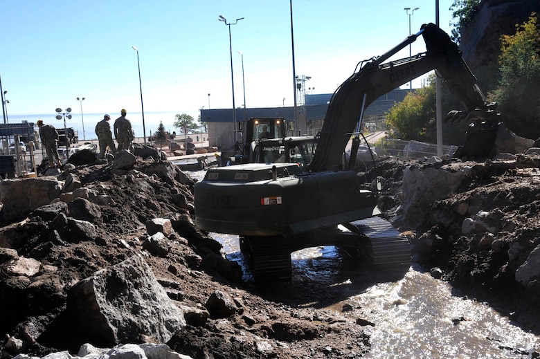 CHEYENNE MOUNTAIN AIR FORCE STATION, Colo. – Soldiers from the 615th Engineer Company, 52nd Engineer Battalion, 4th Infantry Division stationed at Fort Carson, Colo., clear nearly 5,000 cubic yards of debris Sept. 17. The debris was a result of torrential rains that passed through Colorado Sept. 13 and resulted in a mudslide blocking the main entrance of CMAFS. Despite the rockslide, the air defense, space surveillance and missile warning missions inside of the mountain remained 100 percent operational. (U.S. Air Force photo/Rob Lingley)