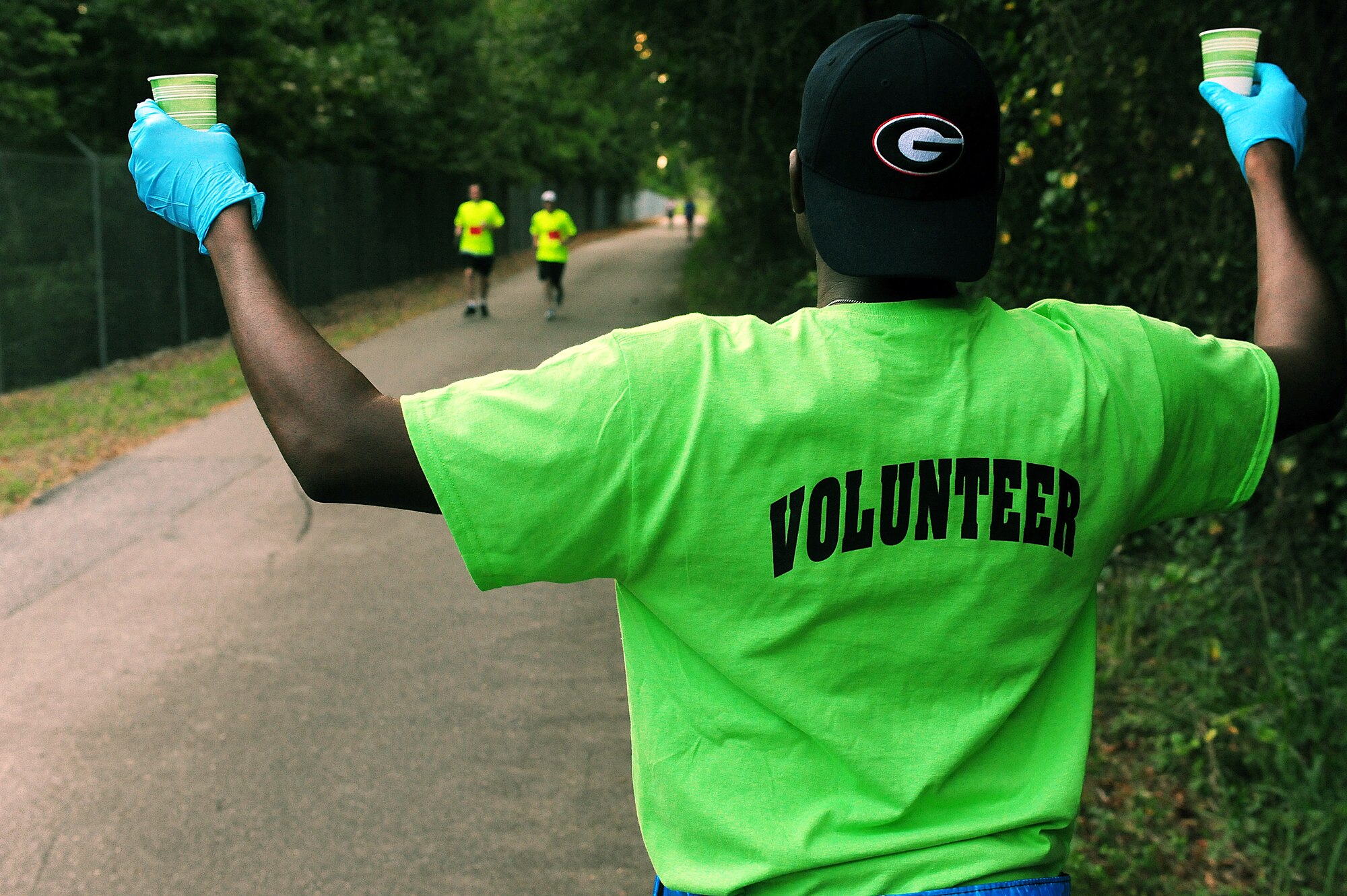 Volunteers stationed at the half-marathon midpoint provide water for race participants during the Run for the Fallen 5K/Half-Marathon hosted by the 4th Fighter Wing Company Grade Officers’ Council, a private organization made up of Air Force lieutenants and captains, at Seymour Johnson Air Force Base, N.C., Sept. 14, 2013.  Multiple stations were set up throughout the race routes to keep runners motivated and hydrated.  (U.S. Air Force photo by Airman 1st Class Brittain Crolley)