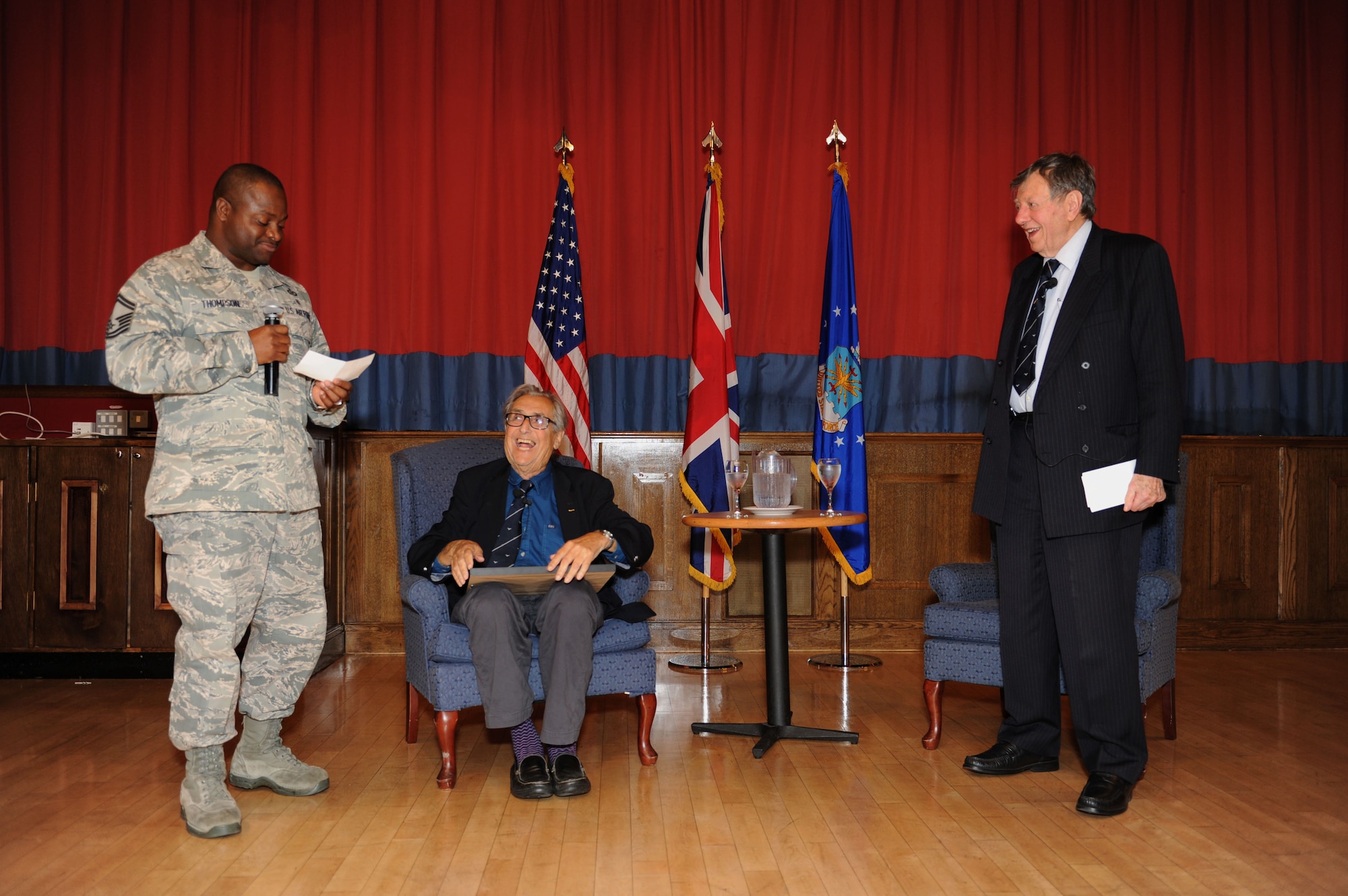 U.S. Air Force Senior Master Sgt. Cornelius Thompson, left, 100th Operations Support Squadron airfield manager, presents retired Royal Air Force Cdre. Charles Clarke, right, a former prisoner of war, with a gift during the Prisoner-Of-War/Missing-In-Action Remembrance Luncheon Sept. 18, 2013, in the Galaxy Club on RAF Mildenhall, England. Clarke and Andrew Wisemen, both POWs during World War II, spoke about their experiences as POWs to Team Mildenhall members. (U.S. Air Force photo by Airman 1st Class Preston Webb/Released)
