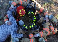 5th Civil Engineer Squadron firefighters huddle together for a prayer before beginning a memorial stair climb at Minot Air Force Base, N.D., Sept. 11, 2013. The team climbed 110 flights of stairs in under an hour to pay tribute to the firefighters who lost their lives in the 9-11 terrorist attacks. (U.S. Air Force photo/Senior Airman Stephanie Sauberan)