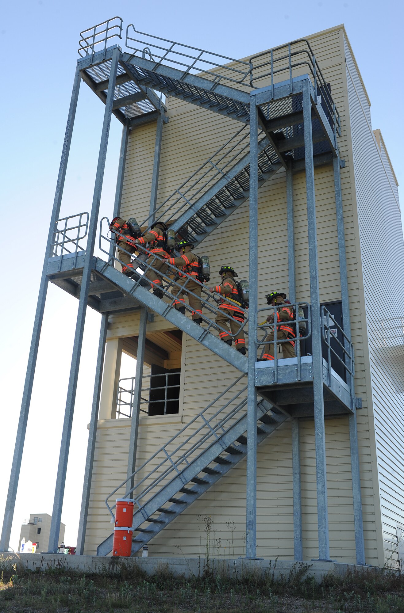 A team of five 5th Civil Engineer Squadron firefighters ascend the outer flight of steps at the firefighter training facility during a memorial stair climb at Minot Air Force Base, N.D., Sept. 11, 2013. The climb, which was completed in under an hour, was part of ceremonial tribute being paid to those who lost their lives in the 2001 attack on the World Trade Center. (U.S. Air Force photo/Senior Airman Stephanie Sauberan)