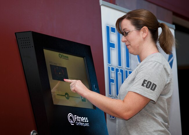 Tech. Sgt. Amanda Rodriguez, 192nd Airlift Squadron personnel specialist from the Nevada Air National Guard at Reno, Nev., uses the “Fitness on Request” kiosk to select a workout Sept. 17, 2013, in the aerobics room of the Warrior Fitness Center at Nellis Air Force Base, Nev. The fitness kiosk offers 30 preloaded workouts to service members, retirees and their families, ranging from kickboxing to basic yoga. (U.S. Air Force photo by Staff Sgt. Michael Charles)