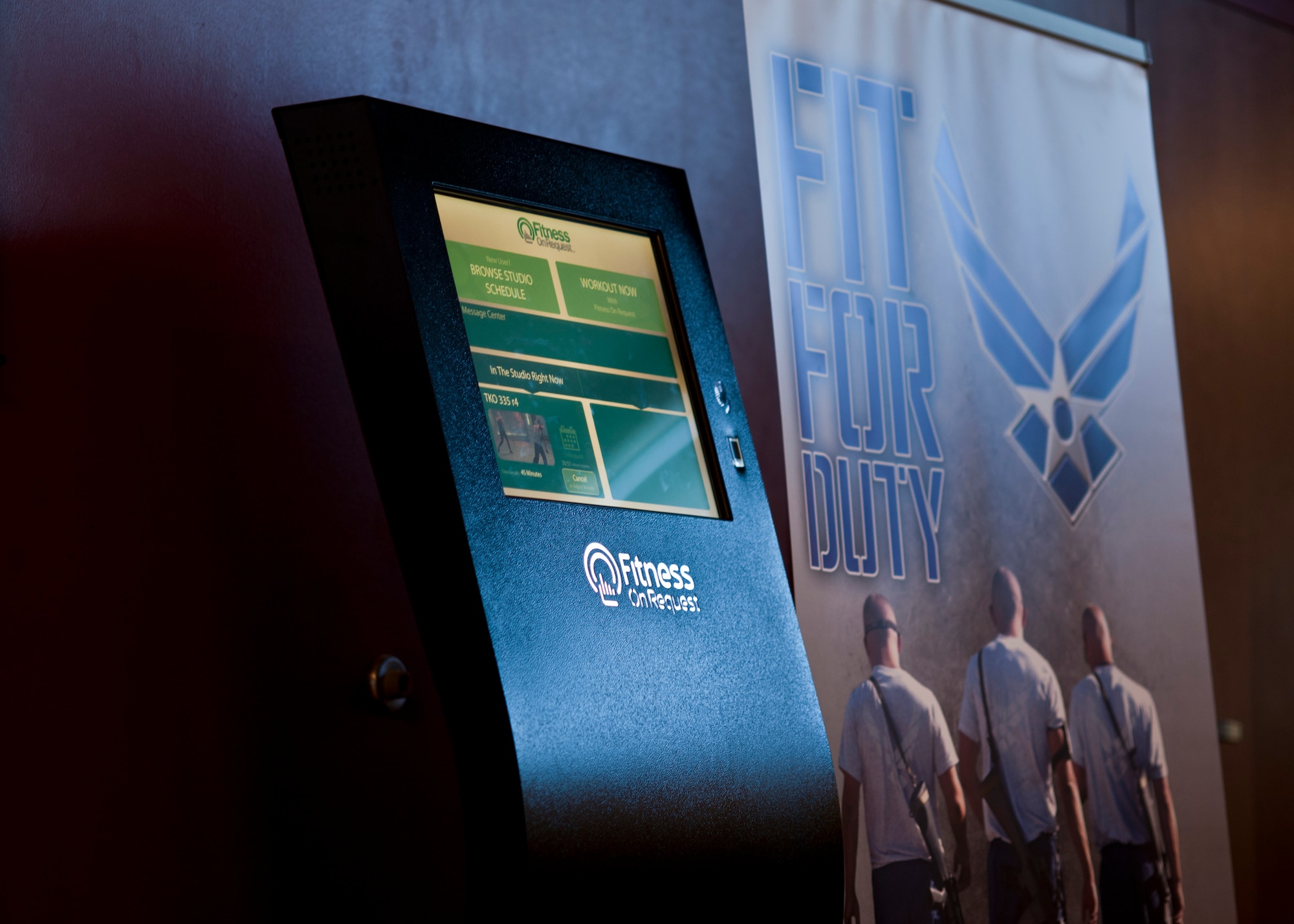 The 99th Force Support Squadron Warrior Fitness Center’s new "Fitness on Request" kiosks were recently activated Sept. 6, 2013, at Nellis Air Force Base, Nev. The kiosk enables fitness staff and customers to schedule group or individual exercise classes where exercise videos will play on a large screen located in the aerobics room. The Air Force plans to install similar kiosks at 66 locations by the end of September in order to help improve total force fitness levels as part of its Operational Fitness Program. (U.S. Air Force photo by Staff Sgt. Michael Charles)
