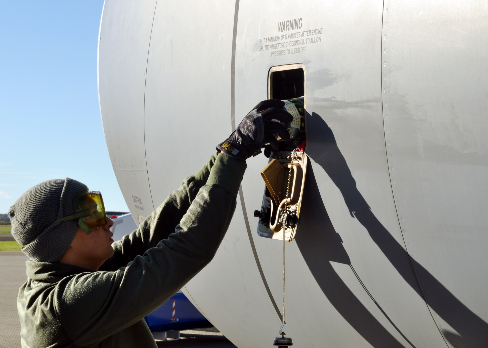 U.S. Air Force Staff Sgt. Samuel Dahlgren-Castillo, 100th Aircraft Maintenance Squadron aerospace propulsion journeyman, tops off the oil on a KC-135R after a refueling mission Sept. 17, 2013, on Ørland Main Air Station, Norway. Dahlgren-Castillo and other maintainers from the 100th ARW and the 48th Fighter Wing are supporting the aircraft participating in the Arctic Challenge exercise hosted in Norway. (U.S. Air Force photo by 1st Lt. Christopher Mesnard/Released)