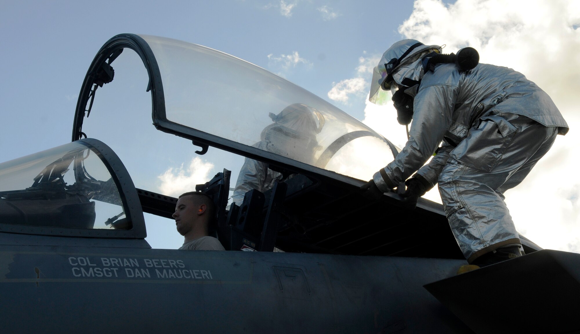 U.S. Air Force Staff Sgt. Trevor Williams, front, and Airman 1st Class Temujin Gutierrez, 18th Civil Engineer Squadron firefighters, force open the canopy of an F-15 Eagle as Airman 1st Class Tyler Randell, 18th CES firefighter, simulates being an unconscious pilot during a local operational readiness exercise on Kadena Air Base, Japan, Sept. 12, 2013. The firefighters receive annual training to stay proficient on emergency aircraft evacuation procedures. (U.S. Air Force photo by Senior Airman Marcus Morris) 
