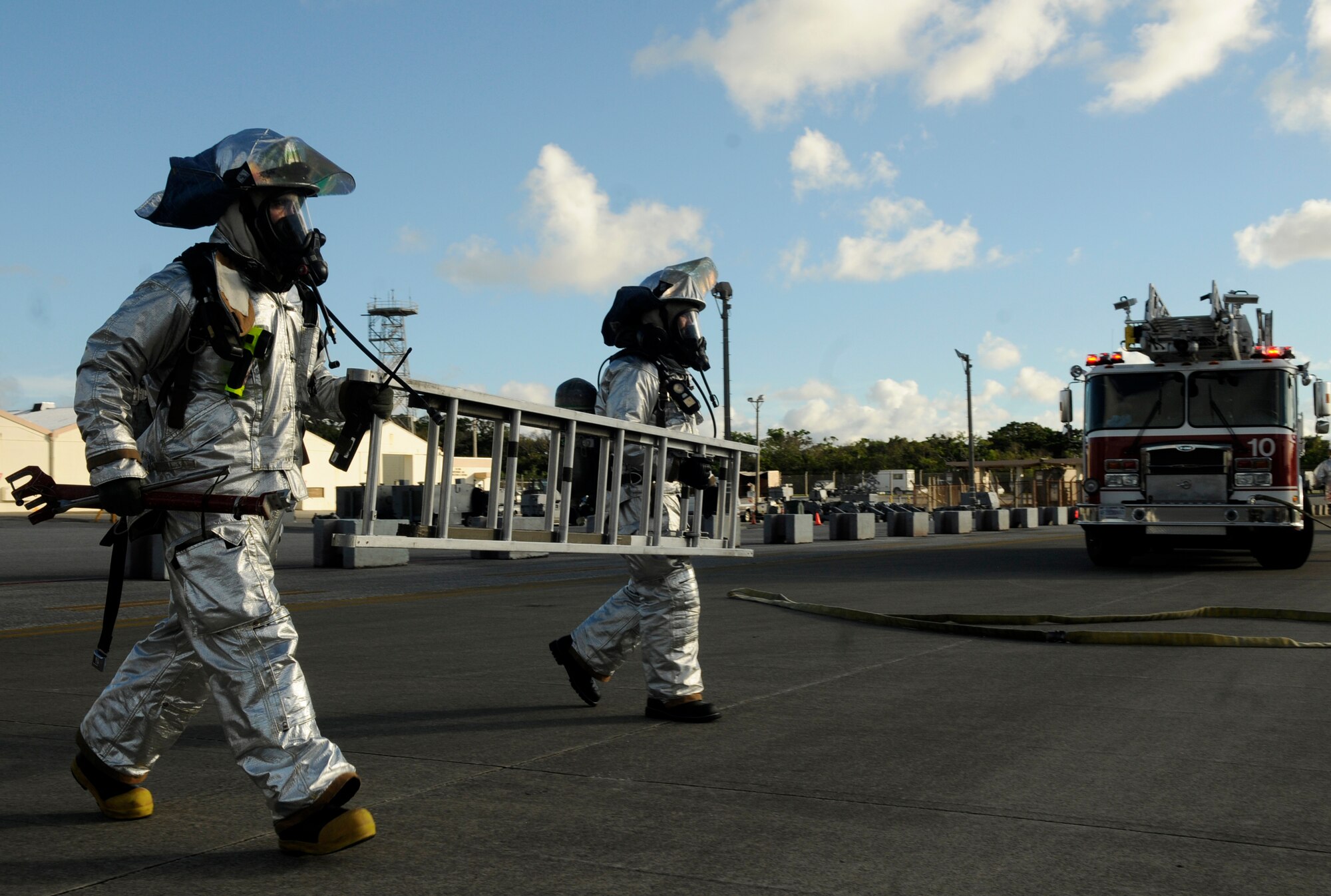 U.S. Air Force Airman 1st Class Temujin Gutierrez and Staff Sgt. Trevor Williams, 18th Civil Engineer Squadron firefighters, carry a ladder to a simulated trapped pilot in an F-15 Eagle during a local operational readiness exercise on Kadena Air Base, Japan, Sept. 12, 2013. Firefighters are trained to quickly put out aircraft fires and rescue the trapped pilots. (U.S. Air Force photo by Senior Airman Marcus Morris)